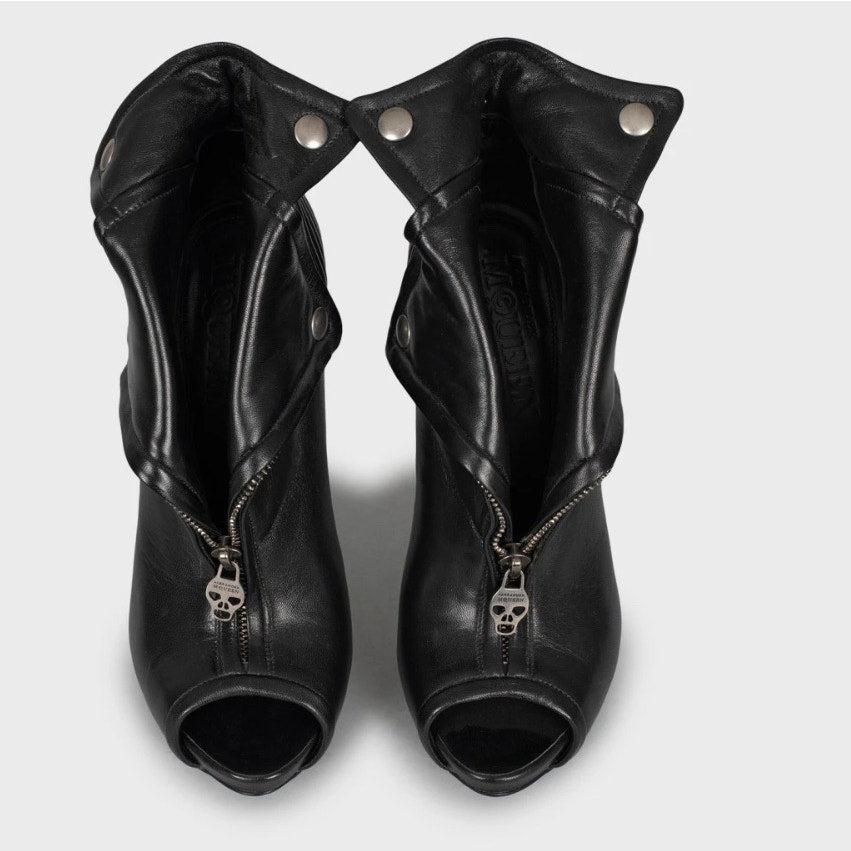 ¡Eleva tu estilo con estos llamativos botines Alexander McQueen! 
Confeccionadas en piel auténtica 100% negra, estas botas presentan un atrevido cierre de cremallera frontal y una elegante silueta perfecta para cualquier ocasión. 
El tacón de aguja