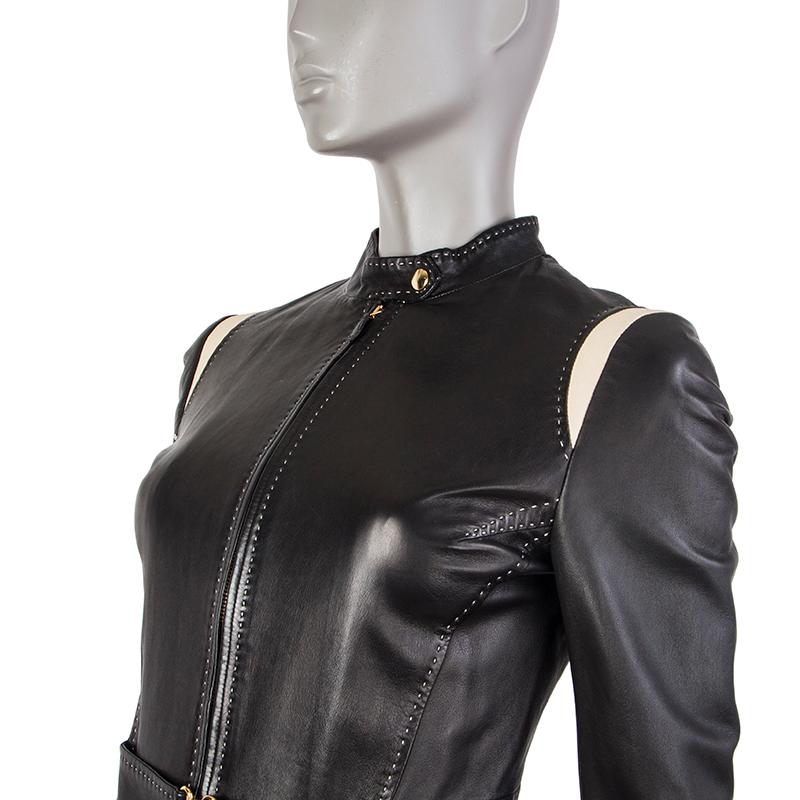 Alexander McQueen biker jacket in black leather. With off-white shoulder panels, off-white stitching, band collar, zipper cuffs, two zipper pockets on the front, and attached hook-buckle belt on the waist. Closes with golden snap at the neck and
