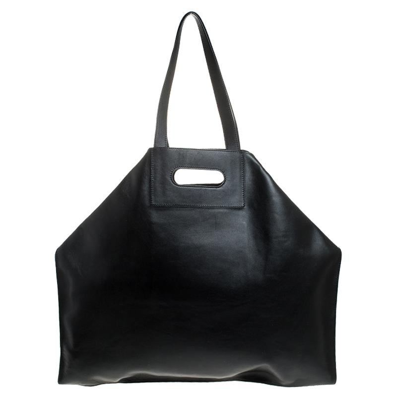 Alexander McQueen brings you this super-edgy tote crafted from leather. This De Manta tote is one-of-a-kind and comes in black. It is held by a single handle and folded top edges that add interest. The bag has a leather-lined interior and is sized