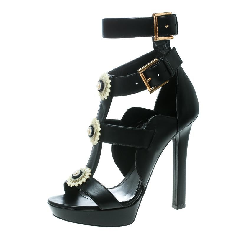 This beautiful pair of Alexander McQueen French Gloss sandals comes in basic design with modern touches. Made from black leather, they feature open toes and bold black straps on the toes, vamps, and ankles. The sandals are ornamented with lovely