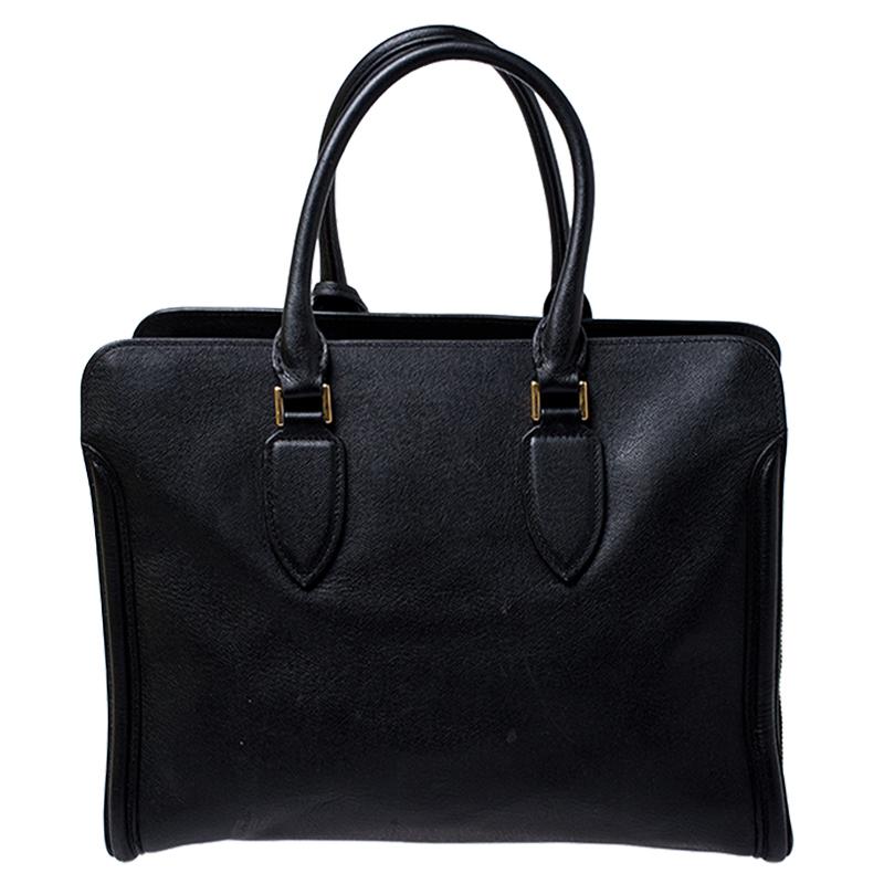 Every woman needs a bag that is lovely and functional, just like this tote from Alexander McQueen. Crafted from leather, it has a spacious canvas interior, two top handles and metal feet. This is definitely one handy bag that deserves to be
