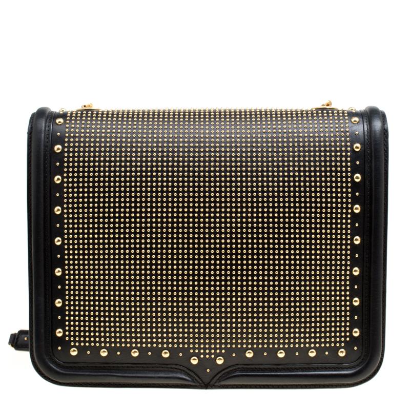 Fabulously designed, this Heroine bag from Alexander McQueen is sure to set hearts racing! It is crafted from leather and features gold-tone studs adorning the exterior. It has a tuck-in front flap closure that opens to reveal a spacious suede lined