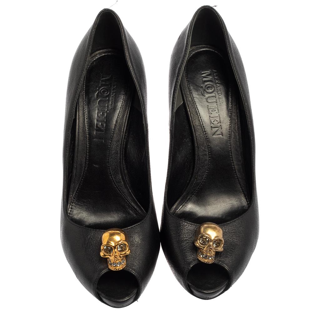Breathtaking and whimsical, these pumps from Alexander McQueen are here to enchant you and make you fall in love with them. These black pumps are crafted from leather and feature a peep-toe silhouette. They flaunt a gold-tone crystal embellished