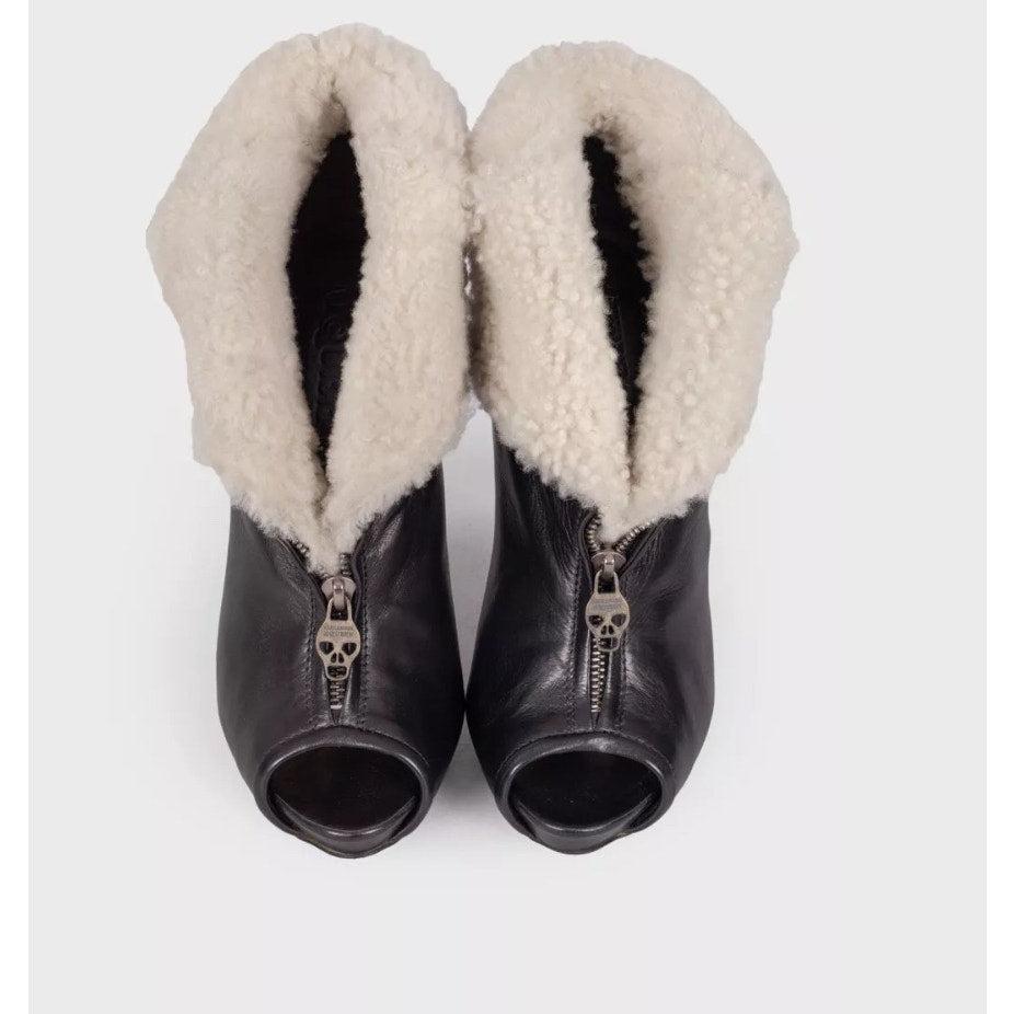 Esci con stile con questi splendidi stivaletti in pelle nera di Alexander McQueen! 
Questi stivali sono caratterizzati da lussuose finiture in shearling che aggiungono un tocco di raffinatezza a qualsiasi abbigliamento. 
Perfetti per le persone alla