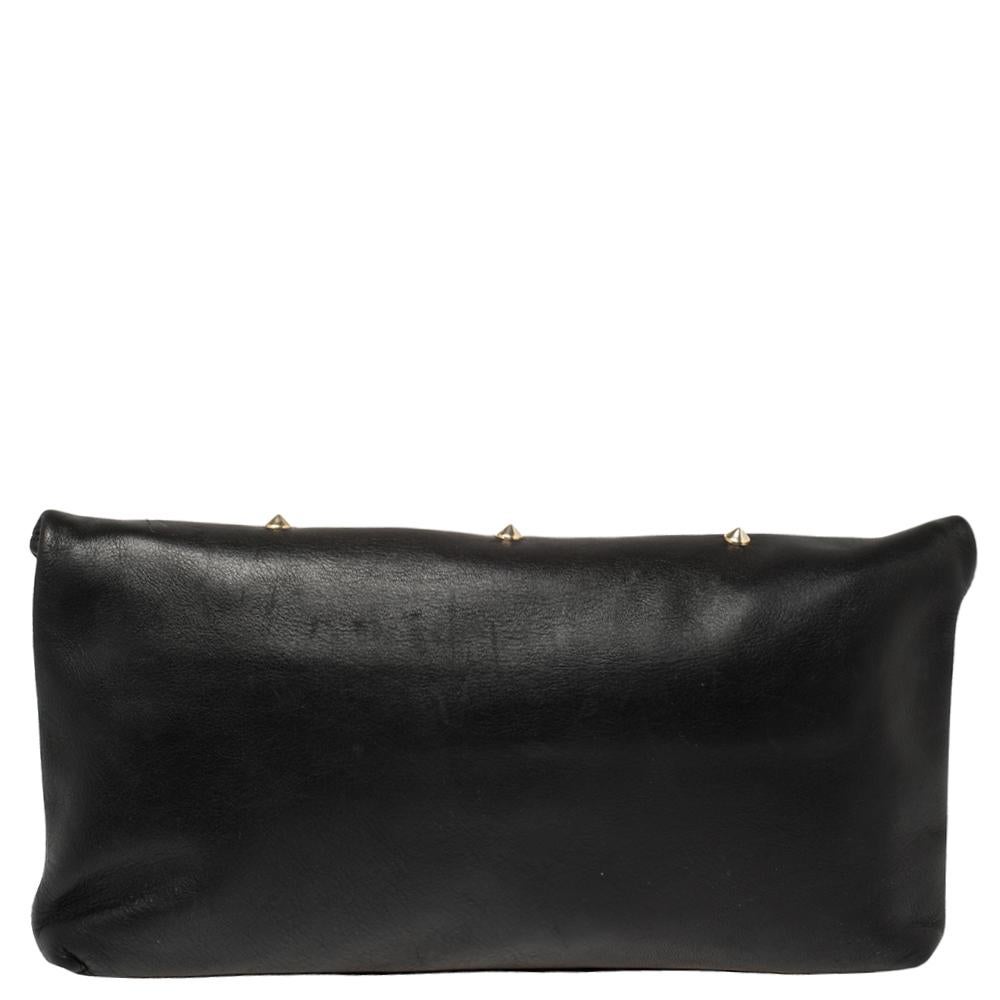 Fashioned in a fold-over silhouette, this Alexander McQueen clutch is designed in black leather. It features gold-tone studs and a skull motif on the front while a zipper leads to a canvas-lined interior that can hold all your evening essentials.

