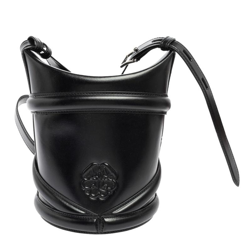 A modern silhouette and a popular new accessory, the Curve bag by Alexander McQueen is a must-have. It takes inspiration from the harness silhouette. The bag we have here is in black leather. It has a circular base and a shoulder strap.

Includes: