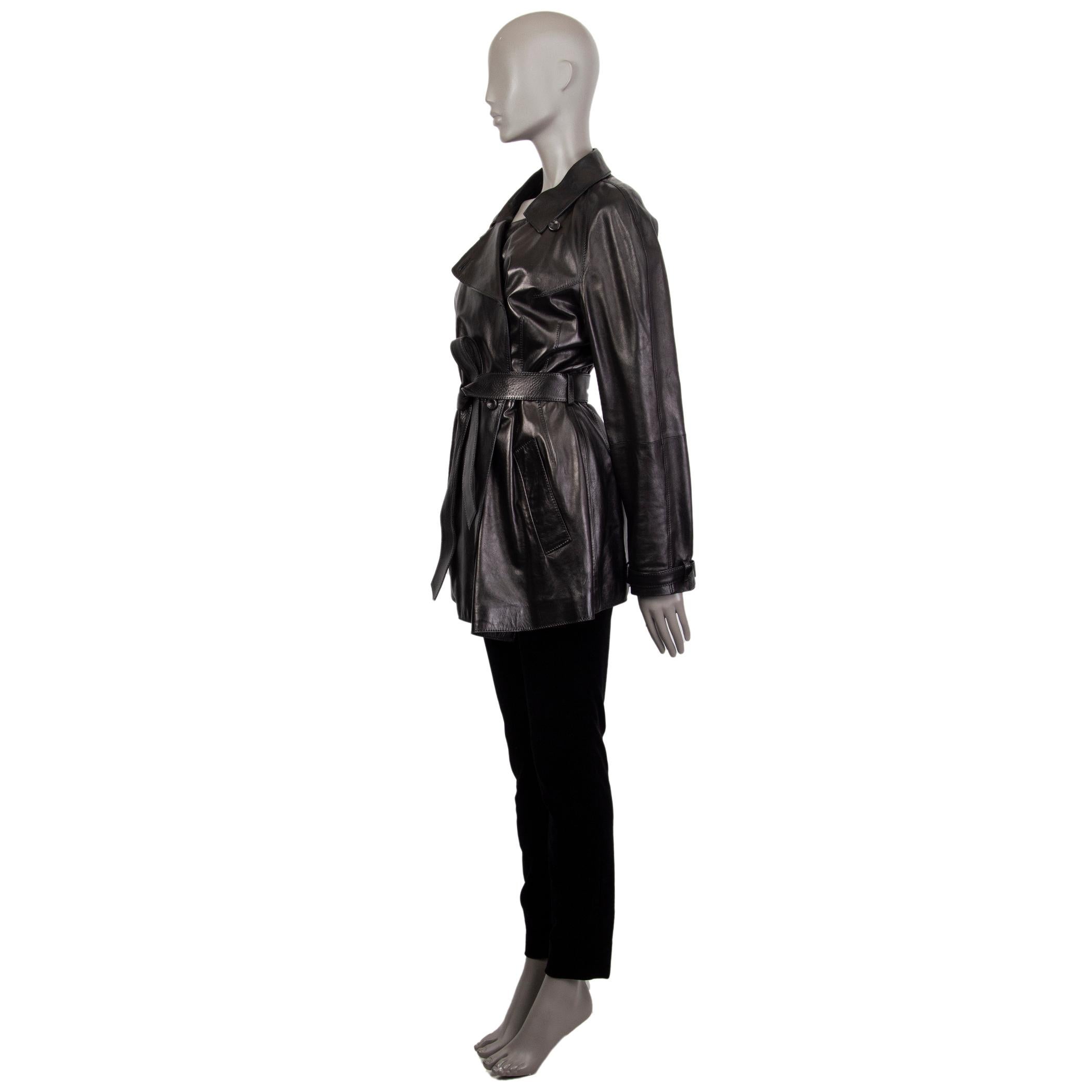 Alexander McQueen double-breasted trench coat in black leather. With flat collar, two pockets on the sides, belt loops around the waist and cuffs, belted cuffs, storm flap on the back, and box pleat on the back. Closes with leather buttons on the
