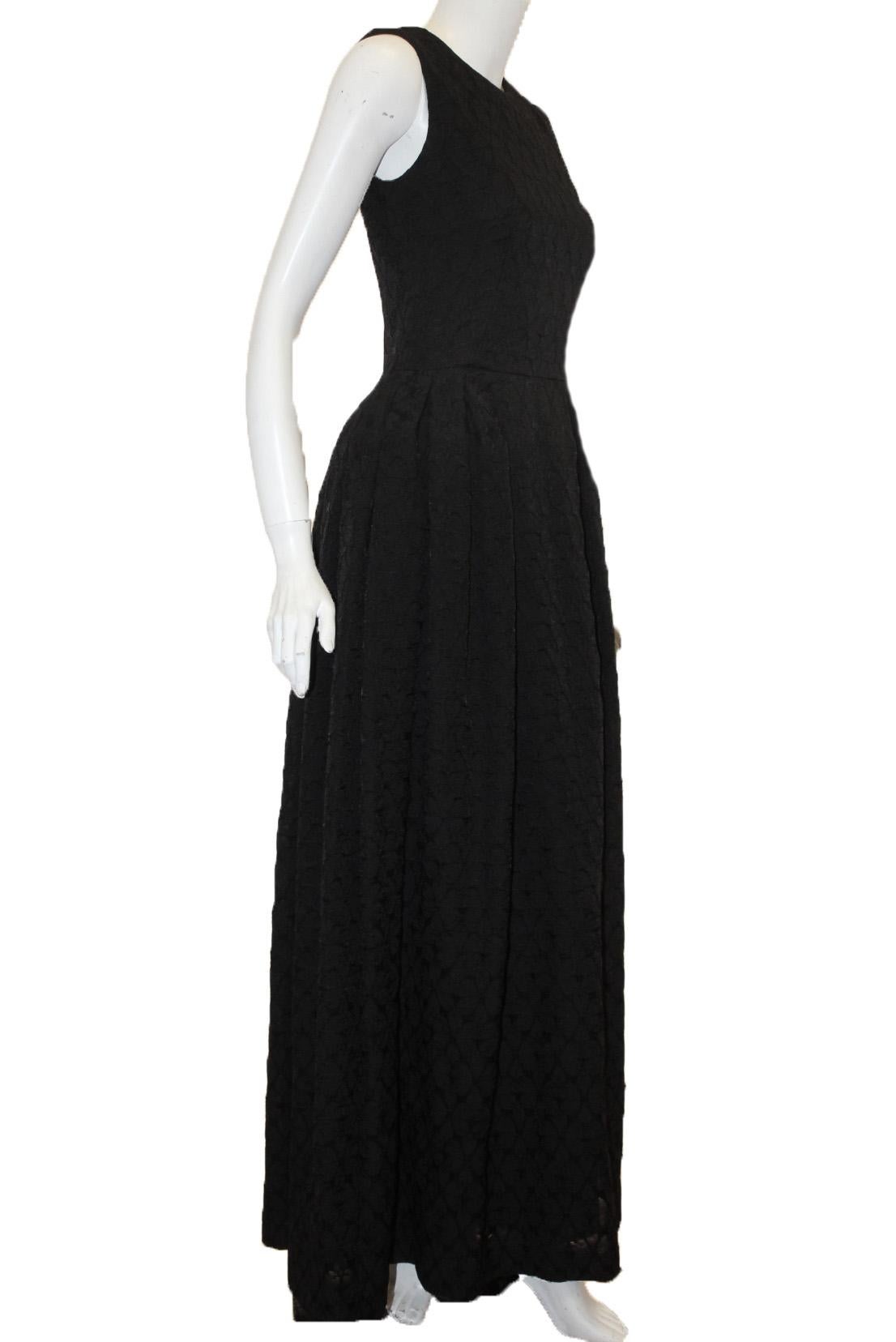 Alexander McQueen black on black round neckline gown is cinched at the waist and contains a full pleated skirt.  This gown is sleeveless and includes a back zipper for closure.  It is impeccably made in Italy.  Dress is fully lined with black silk