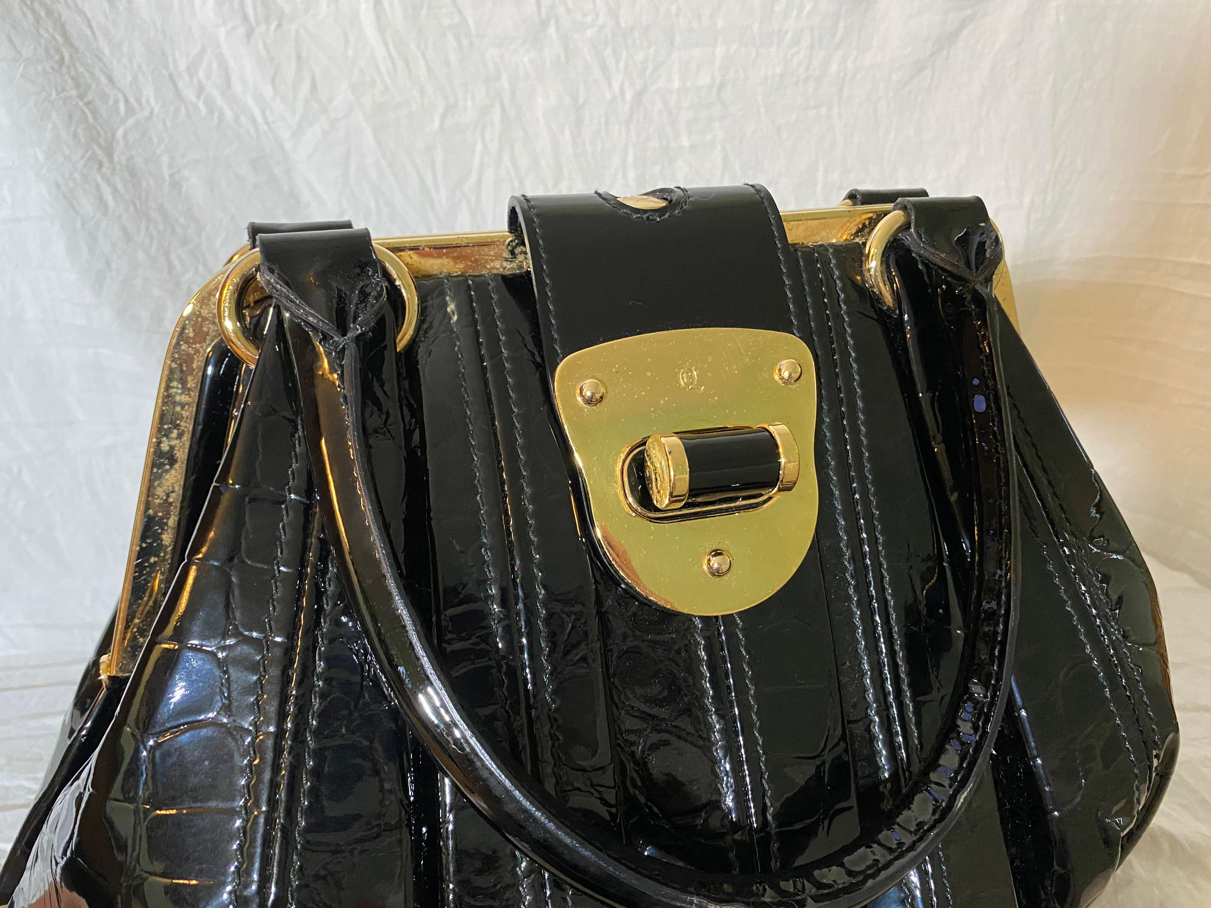 A mid 2000’s favorite, patent crocodile leather laid into structured pleats, gold-tone hardware and a fabric interior. 

Condition: Good used condition.
Exterior: Some tarnishing and scratches on hardware.
Interior: Lined with fabric, one interior