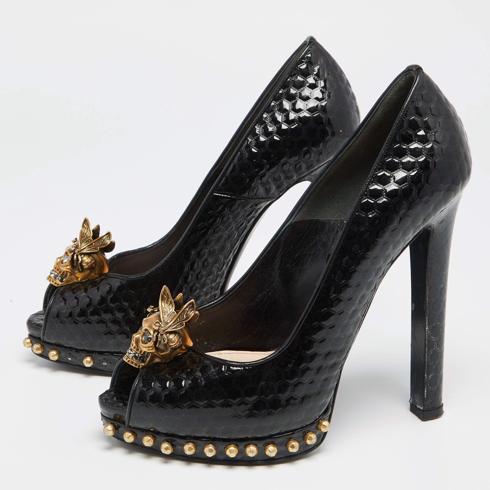 Cette paire d'escarpins signée Alexander McQueen se caractérise par un design raffiné et une confection exquise. Confectionnés en cuir verni gaufré, ces escarpins sont ornés de motifs de têtes de mort sur l'empeigne. Intemporels et élégants, ils