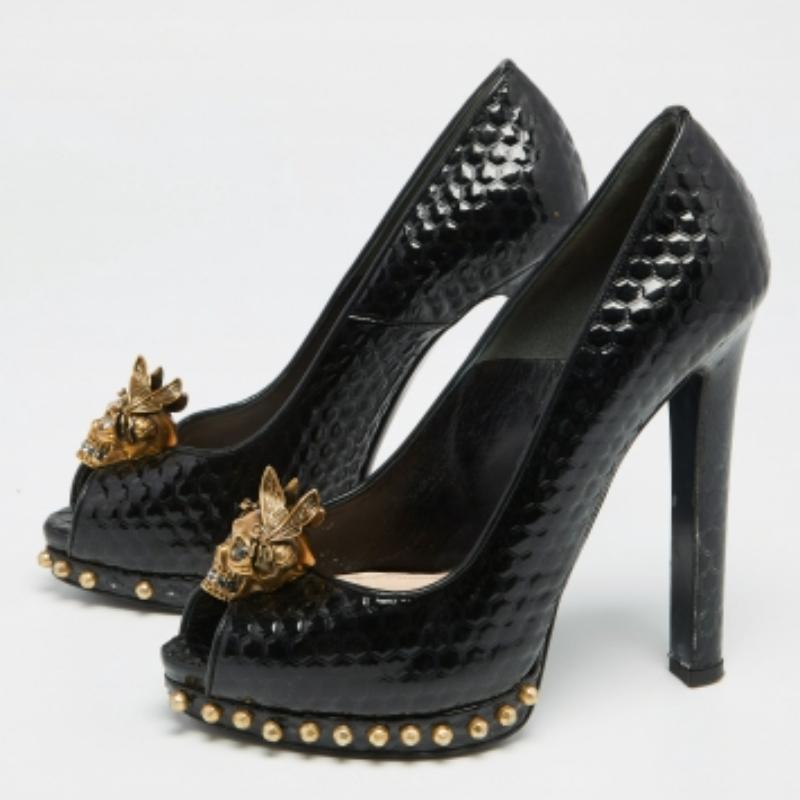 Cette paire d'escarpins signée Alexander McQueen se caractérise par un design raffiné et une confection exquise. Confectionnés en cuir verni gaufré, ces escarpins sont ornés de motifs de têtes de mort sur l'empeigne. Intemporels et élégants, ils