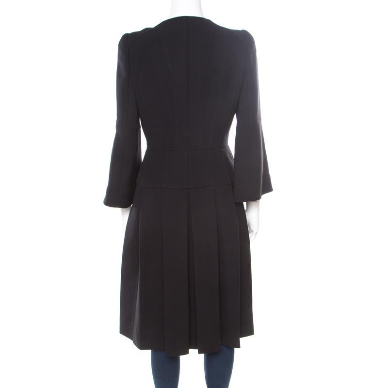 Effortlessly stylish and amazingly chic, this coat dress from Alexander McQueen is all set to win your heart! The black creation is made of a wool blend and features a pleated bottom silhouette. It flaunts wide collars, concealed front button