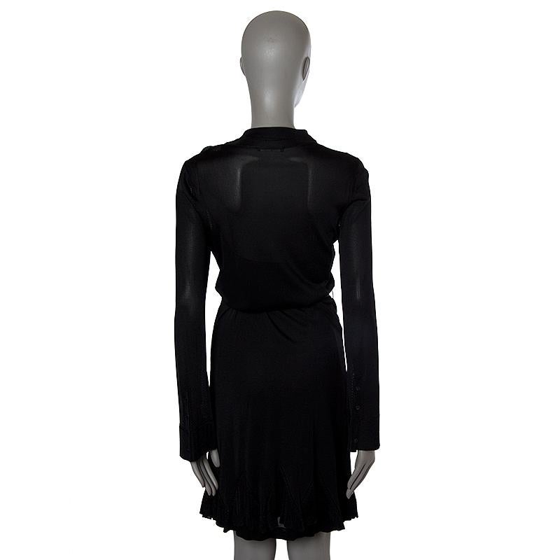 Alexander McQueen sheer knit long-sleeve shirt-dress in black rayon )100%). With flat collar, patch pocket on the chest, buttoned cuffs, godet skirt, belt loops, and belt strap. CLoses with black bottons on the front. Comes with slip in black