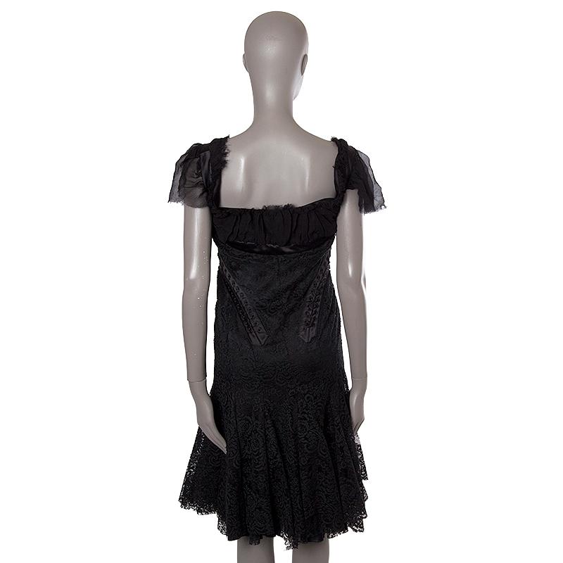 Alexander McQueen lace dress in black silk (38%), cotton (32%), polyester (15%), nylon (13%), and acetate (2%). With fray ruffled sleeves and neck, lace-up details, and trumpet skirt. Closes with one hook and invisible zipper on the front. Features