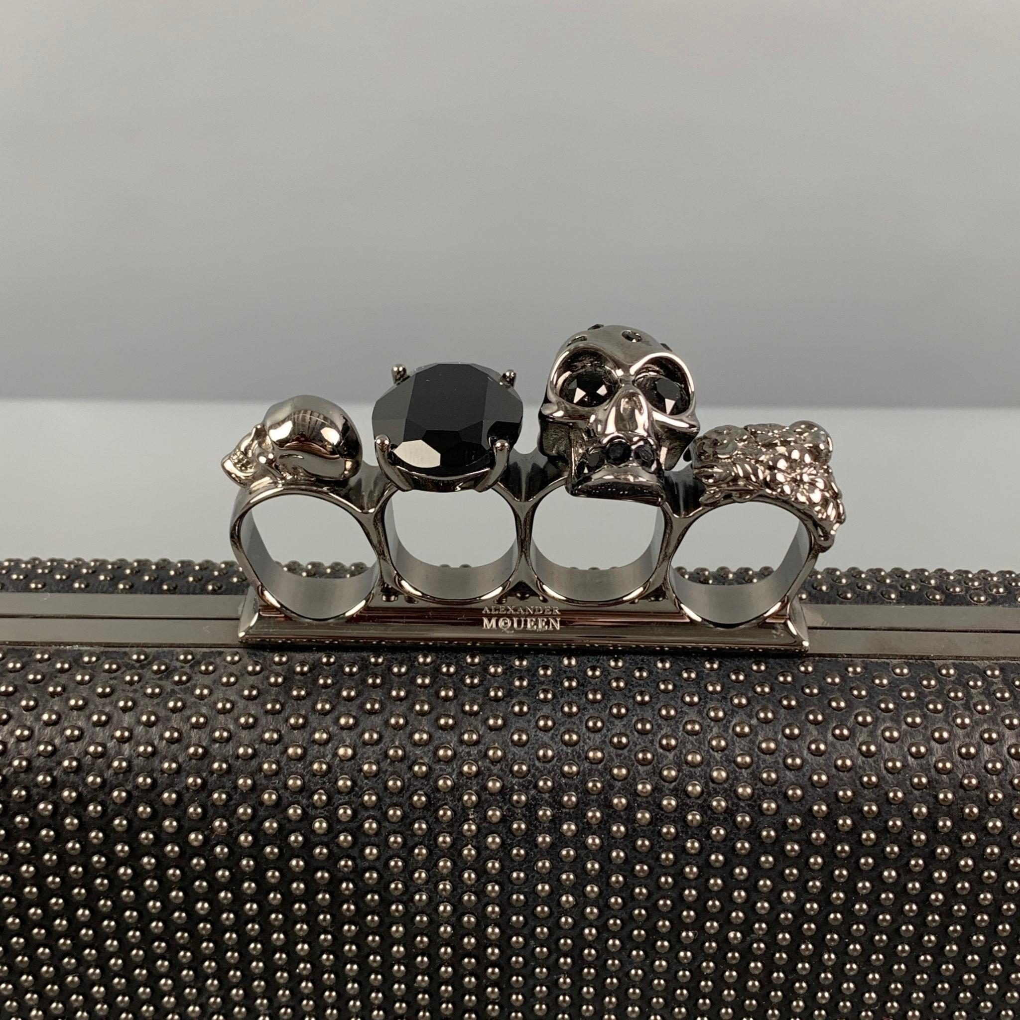 ALEXANDER McQUEEN clutch comes in a black leather with antique silver tone studs featuring swarovski-encrusted rings, four knuckle design, and antique silver finish. Made in Italy. 

Excellent Pre-Owned Condition.
Marked: 229232-000926
Original