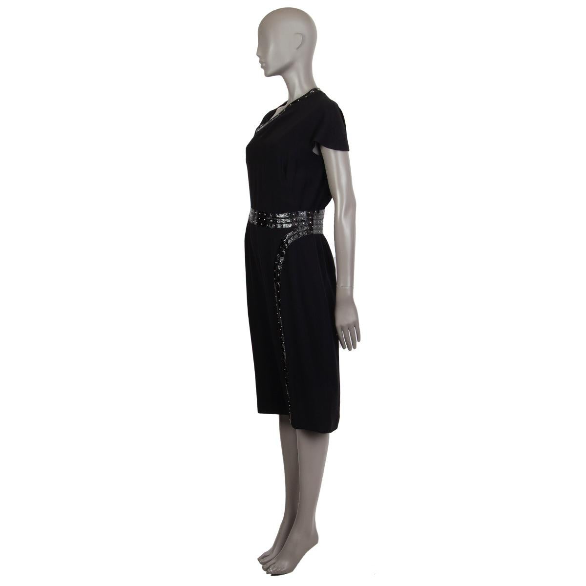 Alexander McQueen patent-trim with studs dress in black acetate (48%) viscose (48%) leather (4%) with an asymmetrical neckline. Has a frontal side slit. Closes on the back with a zipper. Lined in acetate (74%) and silk (26%). Fabric sewing has come