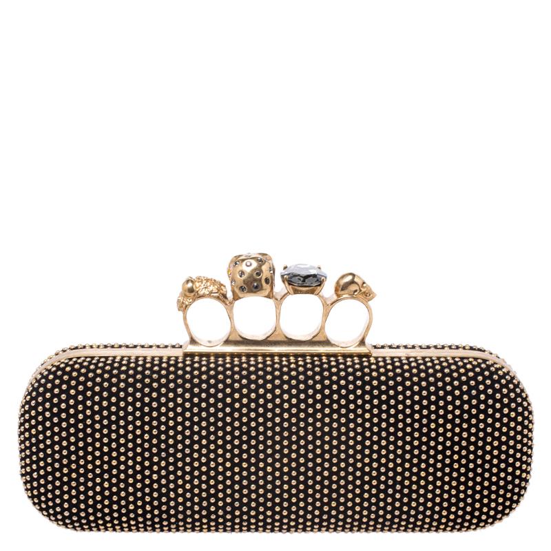 This Box Clutch from Alexander McQueen exudes versatility and luxury. Crafted from gold-tone studded black suede it has a sleek finish and comes with a well-sized interior. This piece is complete with the brand's iconic skull-knuckle fastening.