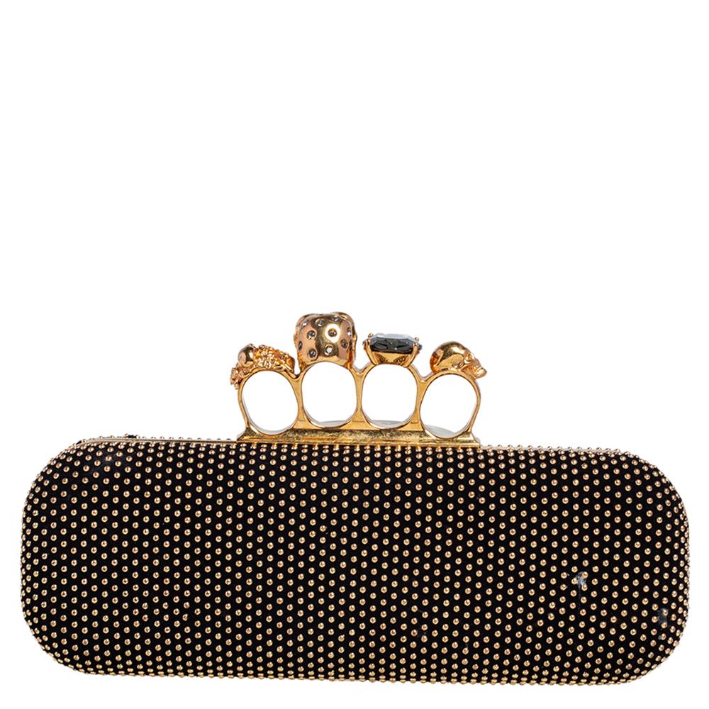 This Knuckle clutch from Alexander McQueen exudes versatility and luxury. Crafted from gold-tone studded black suede, it has a sleek finish and comes with a well-sized interior. This piece is complete with the brand's iconic skull-knuckle fastening.