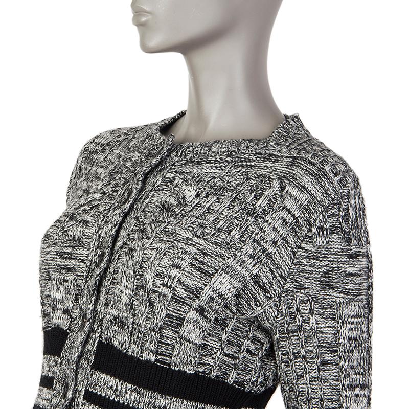 Alexander McQueen mixed cable-knit cardigan in black and white wool (80%), silk (18%)and polyamide (1%) (please note the content tag is missing). With ribbed waist and flared hemline and cuffs. Closes with black plastic buttons on the front. Has