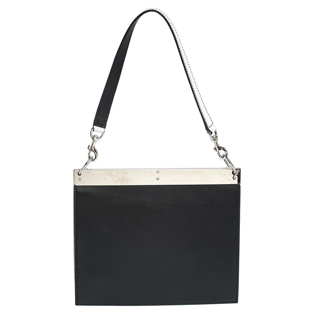 Carefully designed to evoke a timeless and fashionable feel, this leather bag is sure to be a prized possession. It features a black/white exterior with a metal bar on top, a shoulder handle and a spacious suede interior for your essentials. An