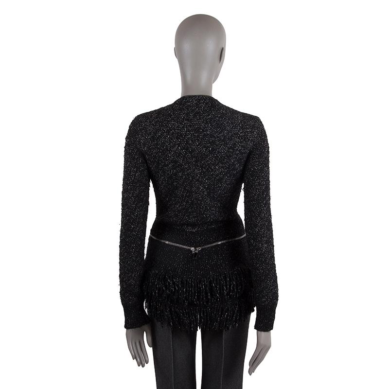 Alexander McQueen boucle cardigan in black and white wool (90%) and cashmere (10%). With fringe trimmings, ribbed details, and decorative dangling hemline on the back. Feature two metal zippers around the waist that meet at the back and closes all