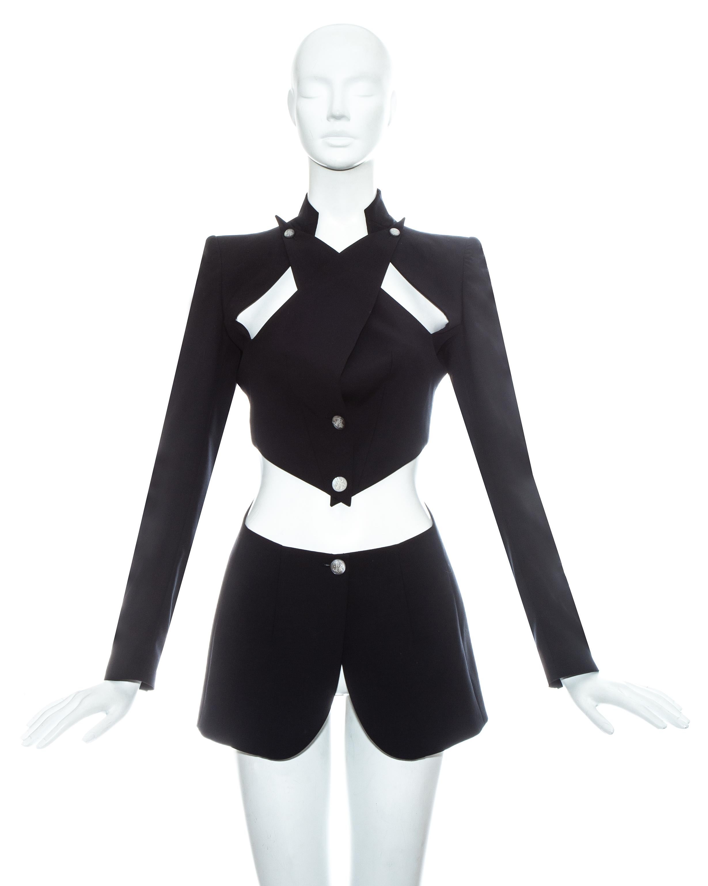 Alexander McQueen; black wool blazer jacket. Exaggerated lapels cross over and fasten on the shoulder line and cut out on the midriff.   

Spring-Summer 1999