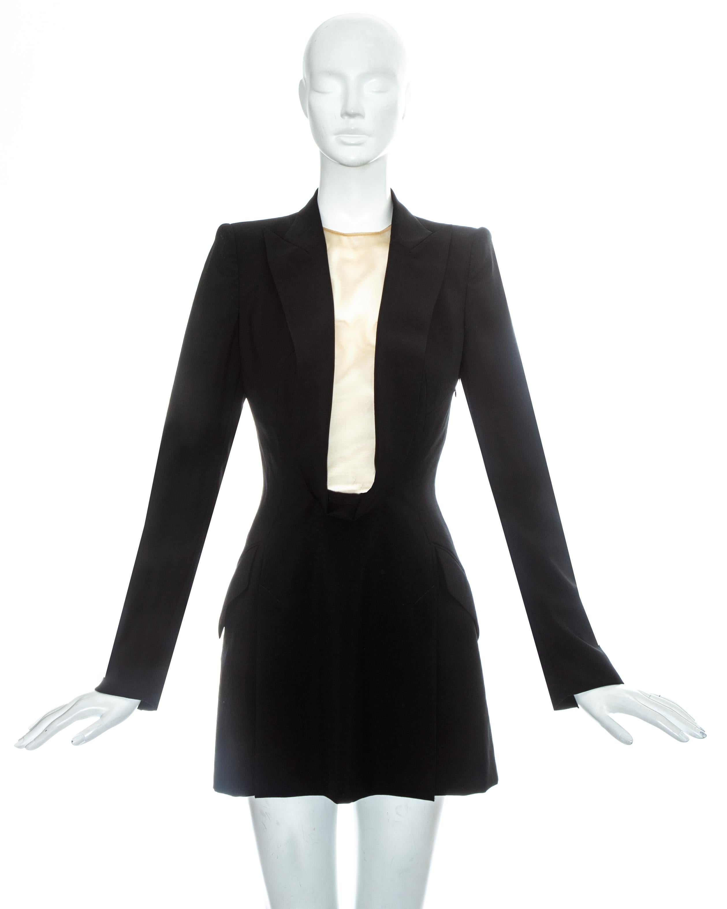 Alexander McQueen black wool blazer mini dress with shawl lapel, deep cleavage with nude mesh and front vent on skirt.

Golden Shower, Spring-Summer 1998