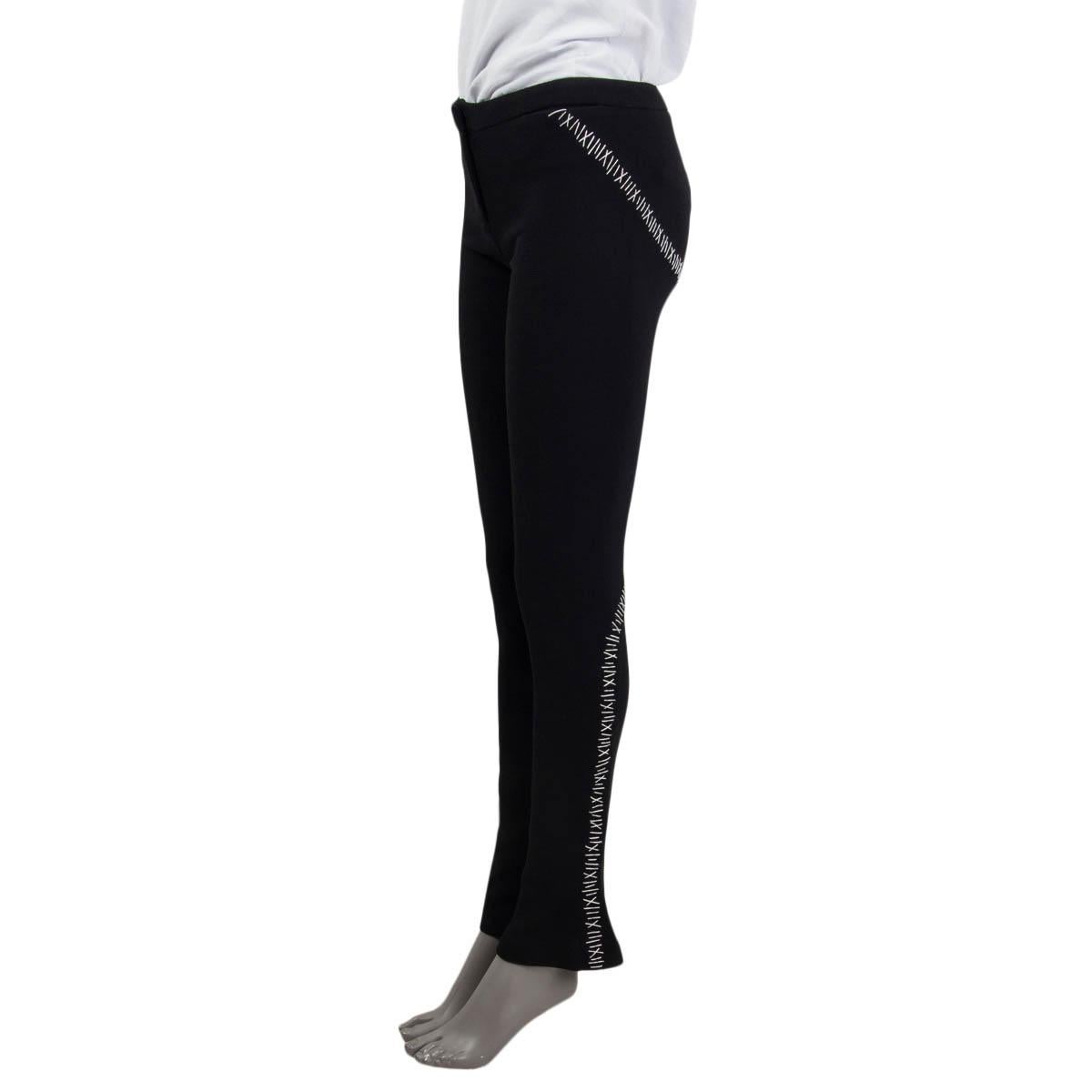 100% authentic Alexander McQueen flared pants in black wool and elastane (assumed cause tag is missing). Feature a white stitched hem, two slit pockets on the front and zipped cuffs. Open with a zipper, hook and a button on the front. Unlined. Have