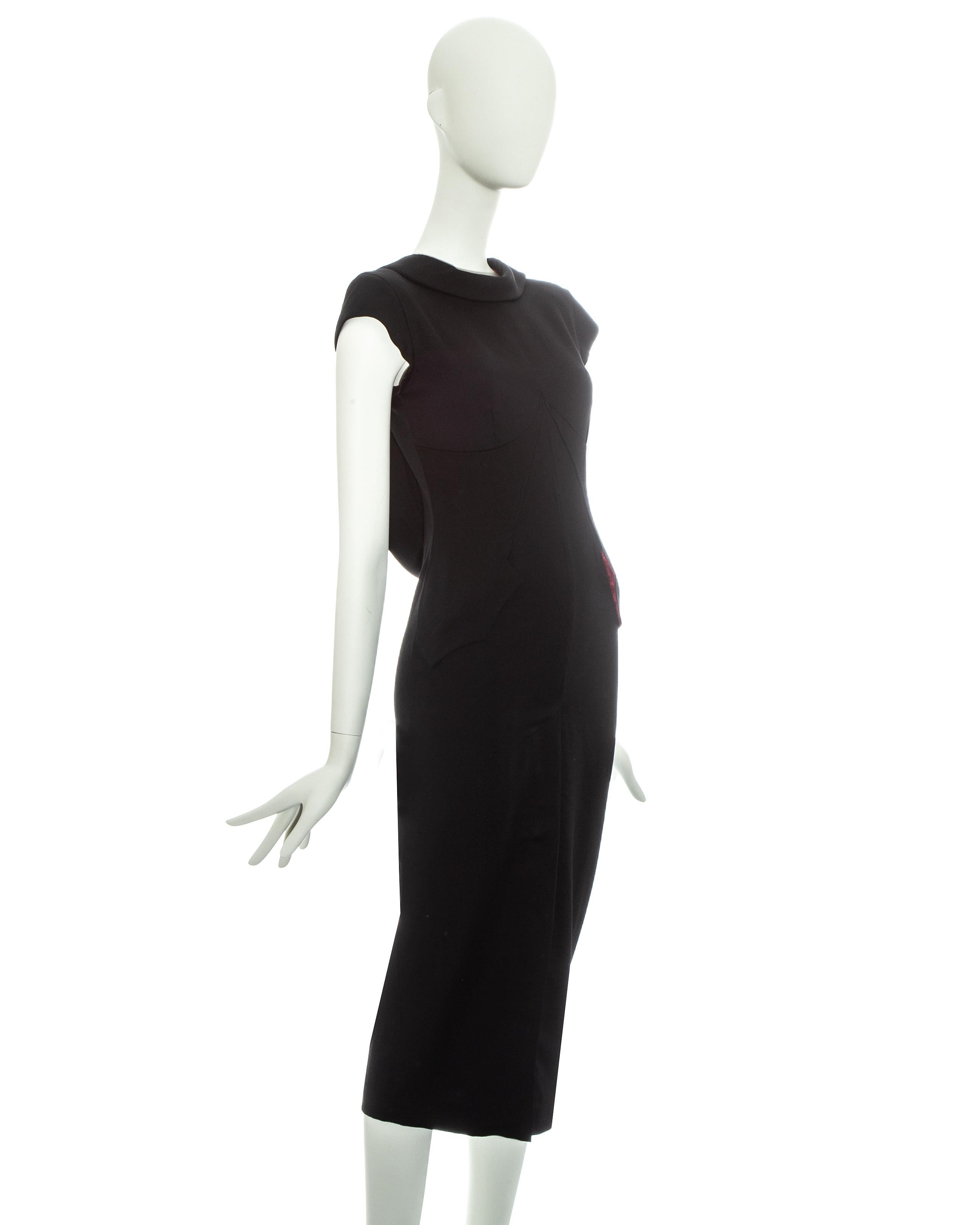 Alexander McQueen black wool fitted mid-length dress with constructed bodice, open back with nude mesh panel, back-to-front shawl lapel, front vent and signature blood red monogram lining. 

Fall-Winter 1998