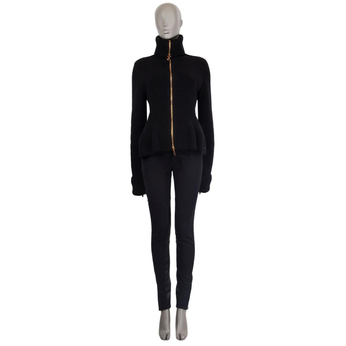 Alexander McQueen knit jacket in black wool (100%) with a long collar to fold down, close silhouette, peplum design, medium to heavy weight, long sleeves with folded cuffs. Unlined. Closes with a golden zipper in the front. Has been worn and is in