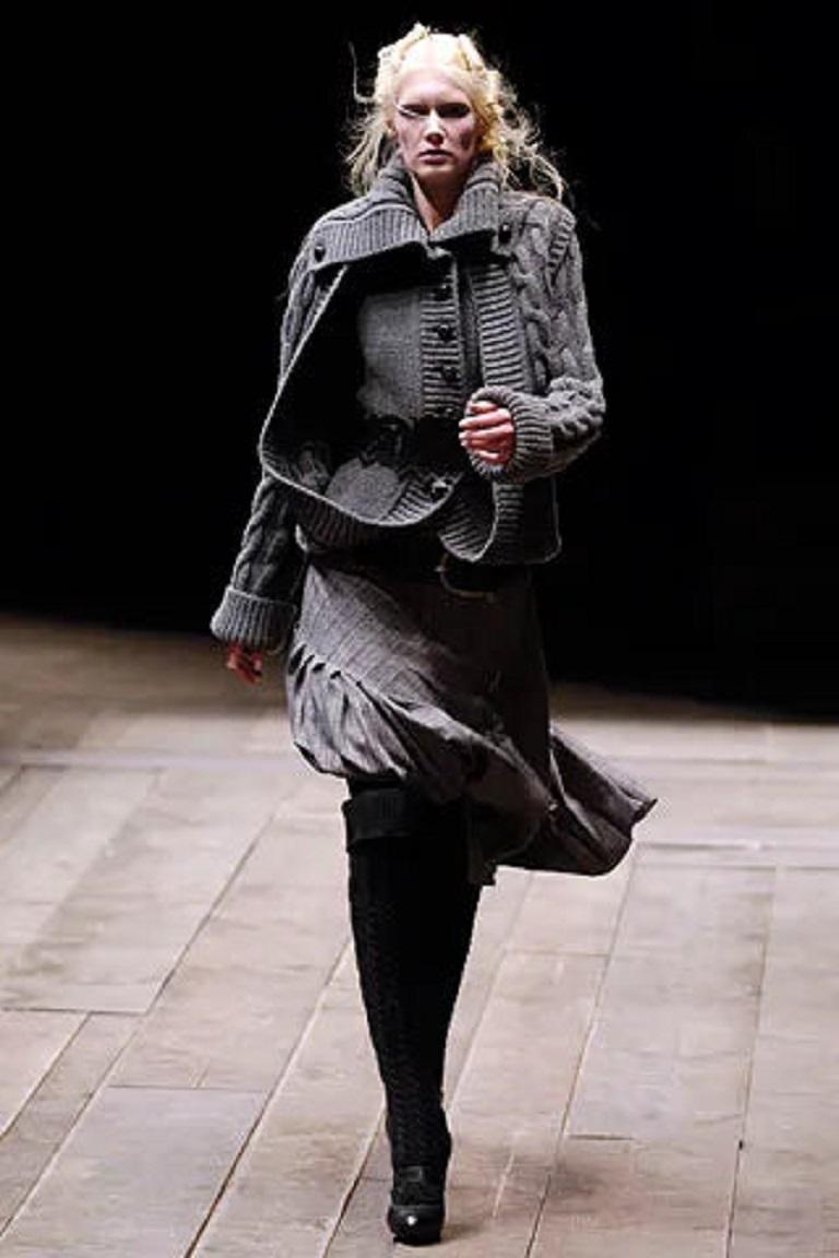 Alexander McQueen - (Fabriqué en Italie) Jupe en laine mélangée dans les tons gris et décorée d'une imposante épingle à nourrice en métal argenté avec strass. Taille 40FR indiquée. Collectional automne-hiver 2006.

Informations complémentaires