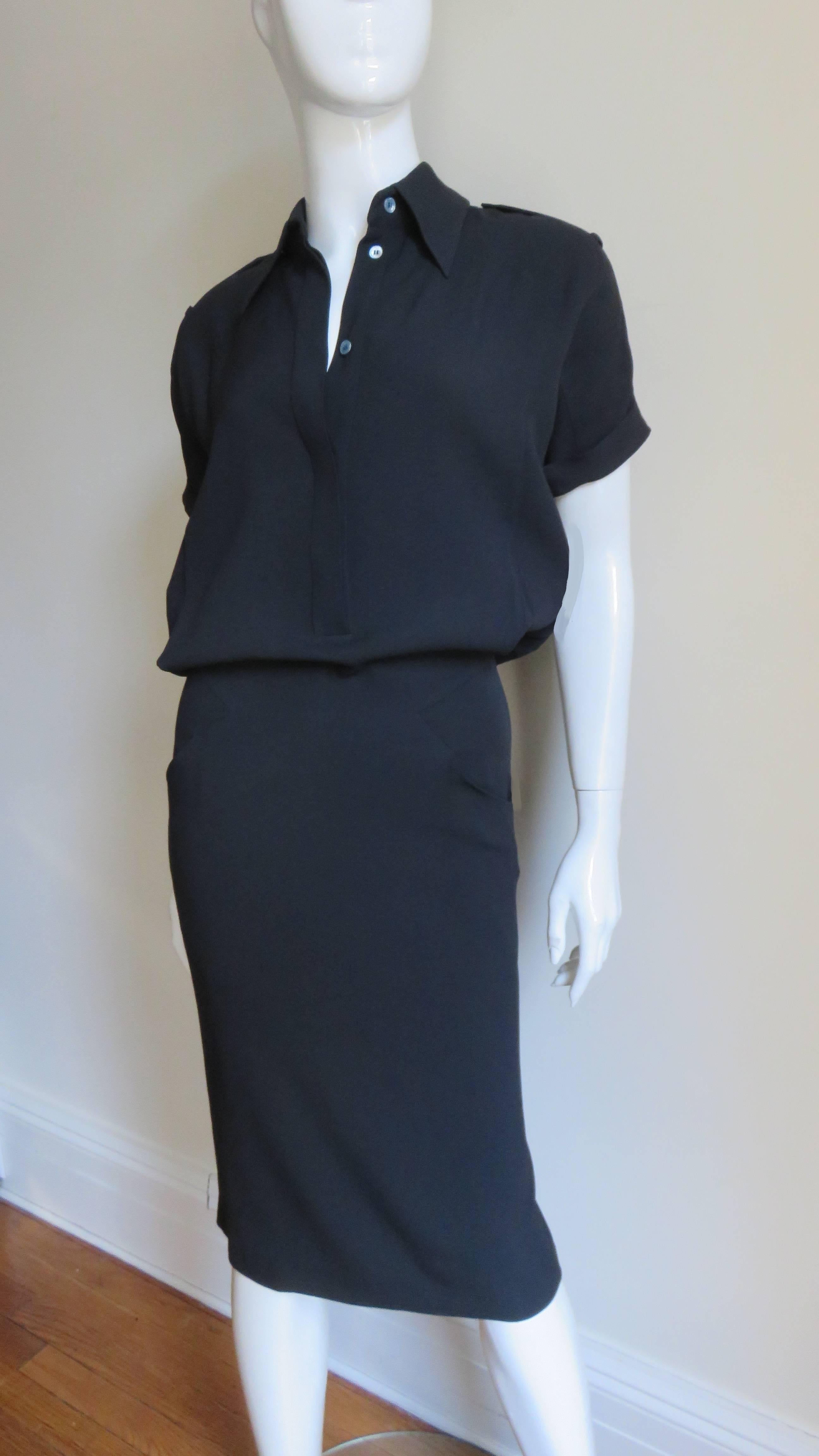 A fabulous chic black shirtwaist dress by Alexander McQueen.  The blouson bodice has a shirt collar, short cuffed dolman sleeves, a back yoke, shoulder epaulettes with buttons and platinum colored mother of pearl buttons in a placket up the front.