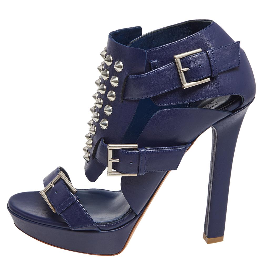 These Alexander McQueen sandals are a reflection of the label's immaculate artistry in shoemaking. Crafted from blue leather, the silhouette is detailed with studs, adorned with buckles, and raised on sturdy heels supported by platforms. Style them