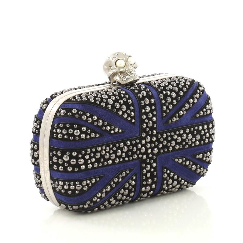 This Alexander McQueen Britannia Skull Box Clutch Studded Suede Small, crafted with black and blue studded suede, features Union Jack flag inspired studs design, hinged metal frame, and aged silver-tone hardware. Its skull clasp closure opens to a