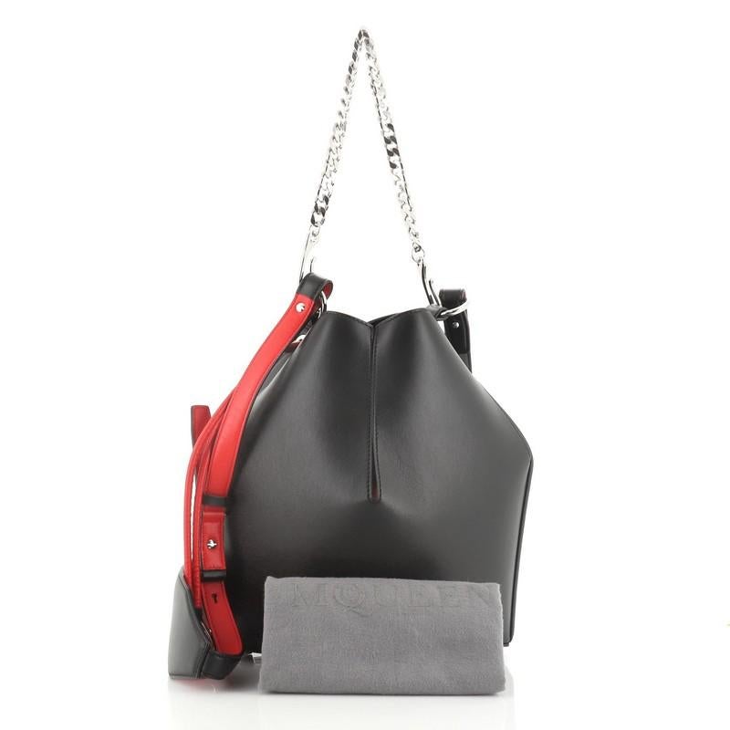 This Alexander McQueen Bucket Bag Leather Medium, crafted in black and red leather, features a chain-link handle, leather shoulder strap. Its cinch closure opens to a black microfiber interior.

Estimated Retail Price: $2,490
Condition: Great. Minor