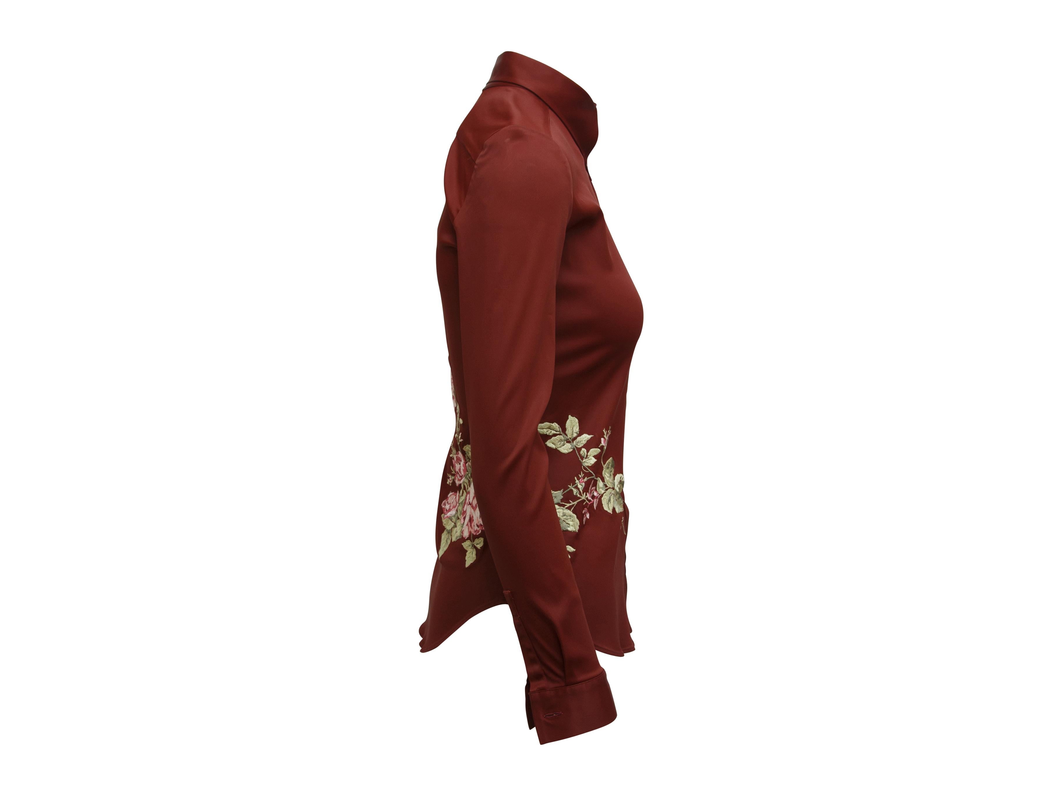 Product details:  Burgundy floral embroidered blouse by Alexander McQueen.  From the Fall 1997 collection.  Asymmetrical point collar.  Long sleeves.  Single button cuffs.  Button-front closure.  Shirttail hem.  32