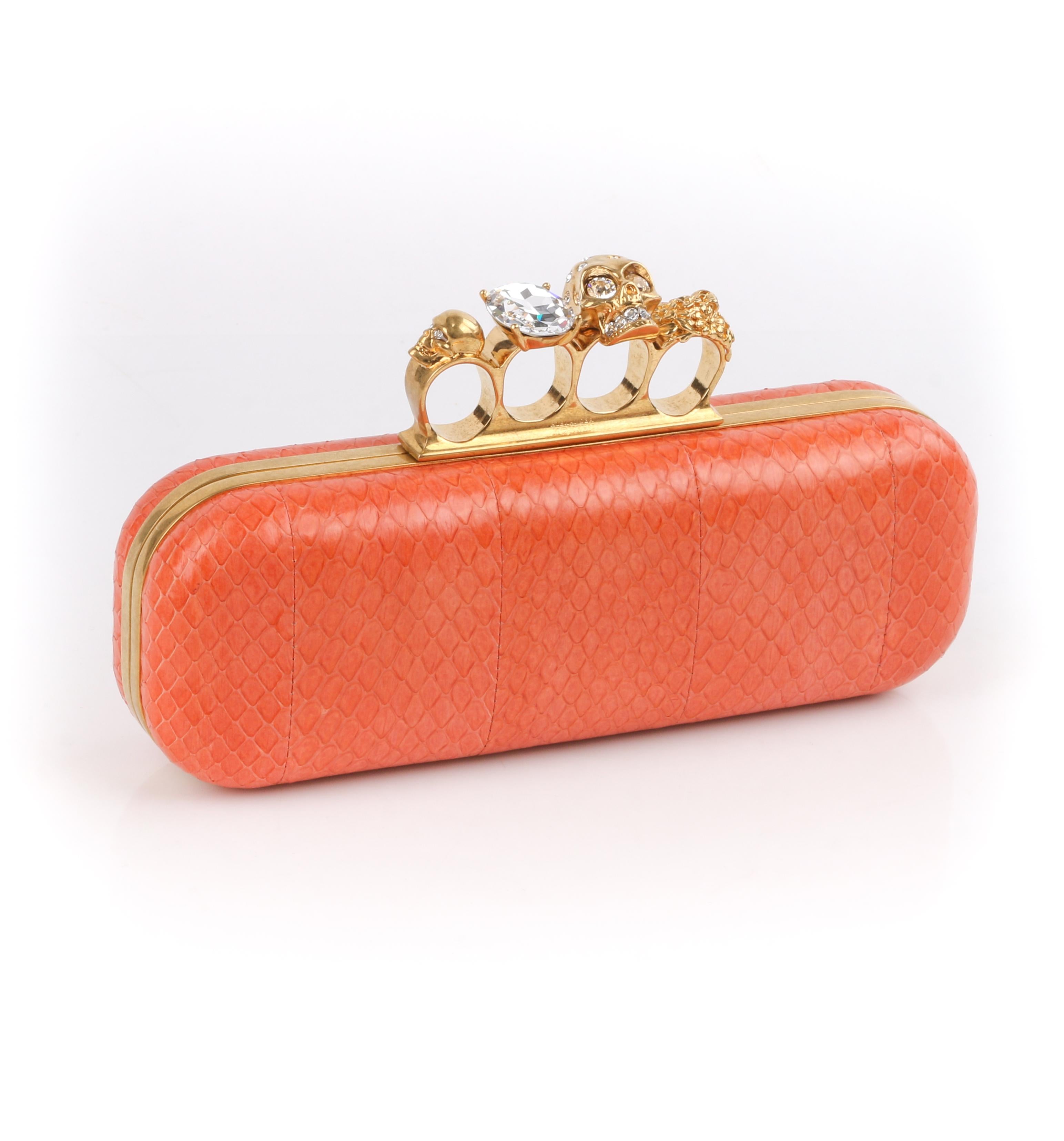 DESCRIPTION: ALEXANDER McQUEEN Coral Python Skull Crystal Knuckle Duster Box Clutch 
 
Estimated Retail: $2,545
 
Brand / Manufacturer: Alexander McQueen 
Style: Clutch
Color(s): Orange
Lined: Yes
Unmarked Fabric Content: Python snakeskin, leather,