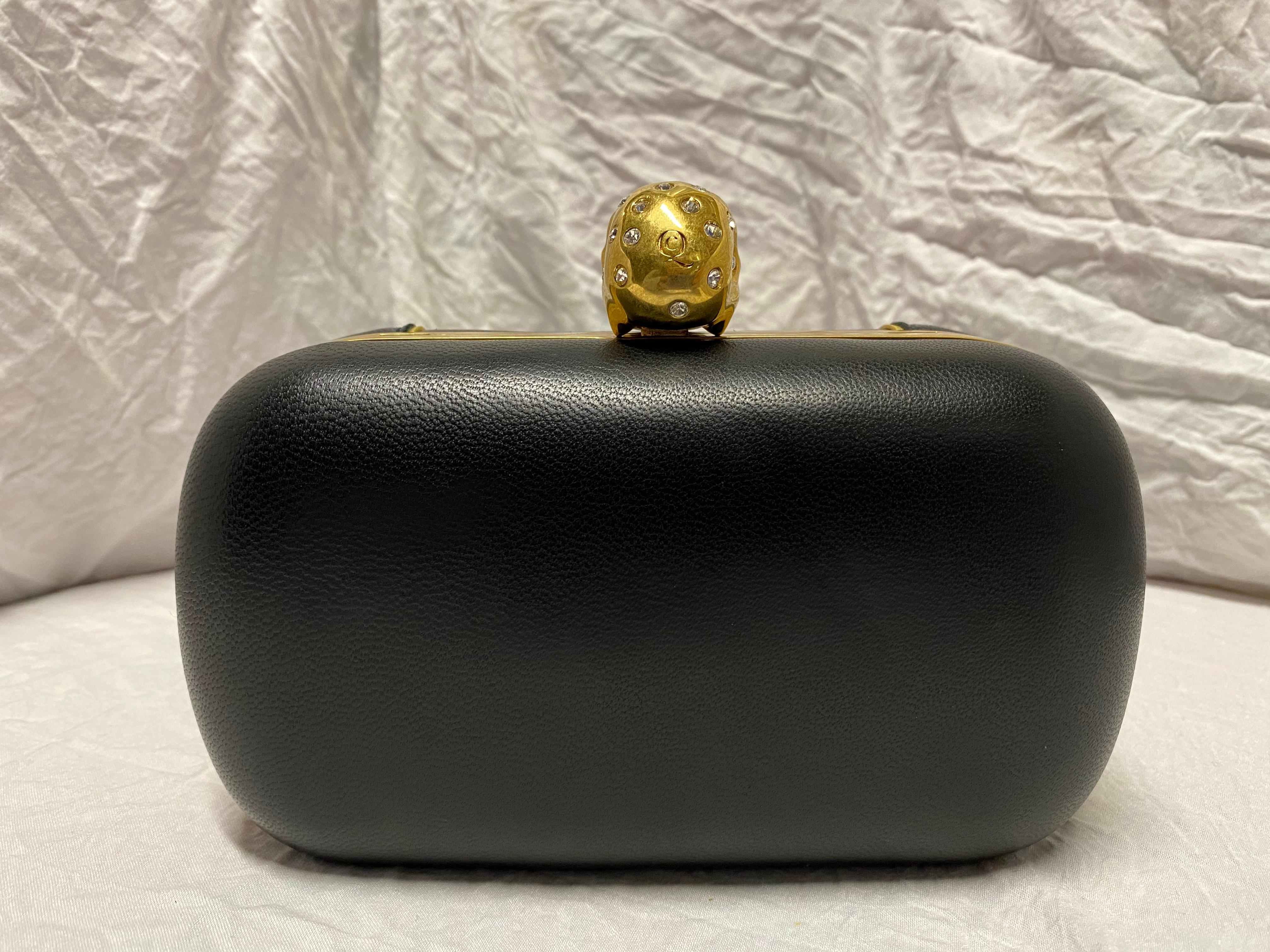 Made with full grain leather dyed an onyx black, dusted gold-tone hardware, Swarovski crystals, and a detachable strap. 

Condition: Like new, never used, comes with tags. 
Exterior: All stones intact. 
Interior: Lined with leather
Made In: