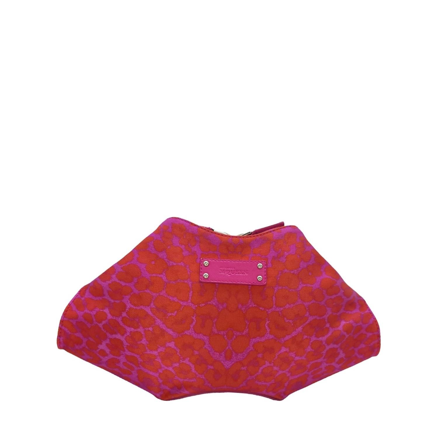Express yourself in style with the Alexander McQueen De Manta Clutch. This playful pink and red leopard printed satin clutch is perfect for the bold and fashion-forward. With a roomy main compartment and interior zip pocket, it's perfect for
