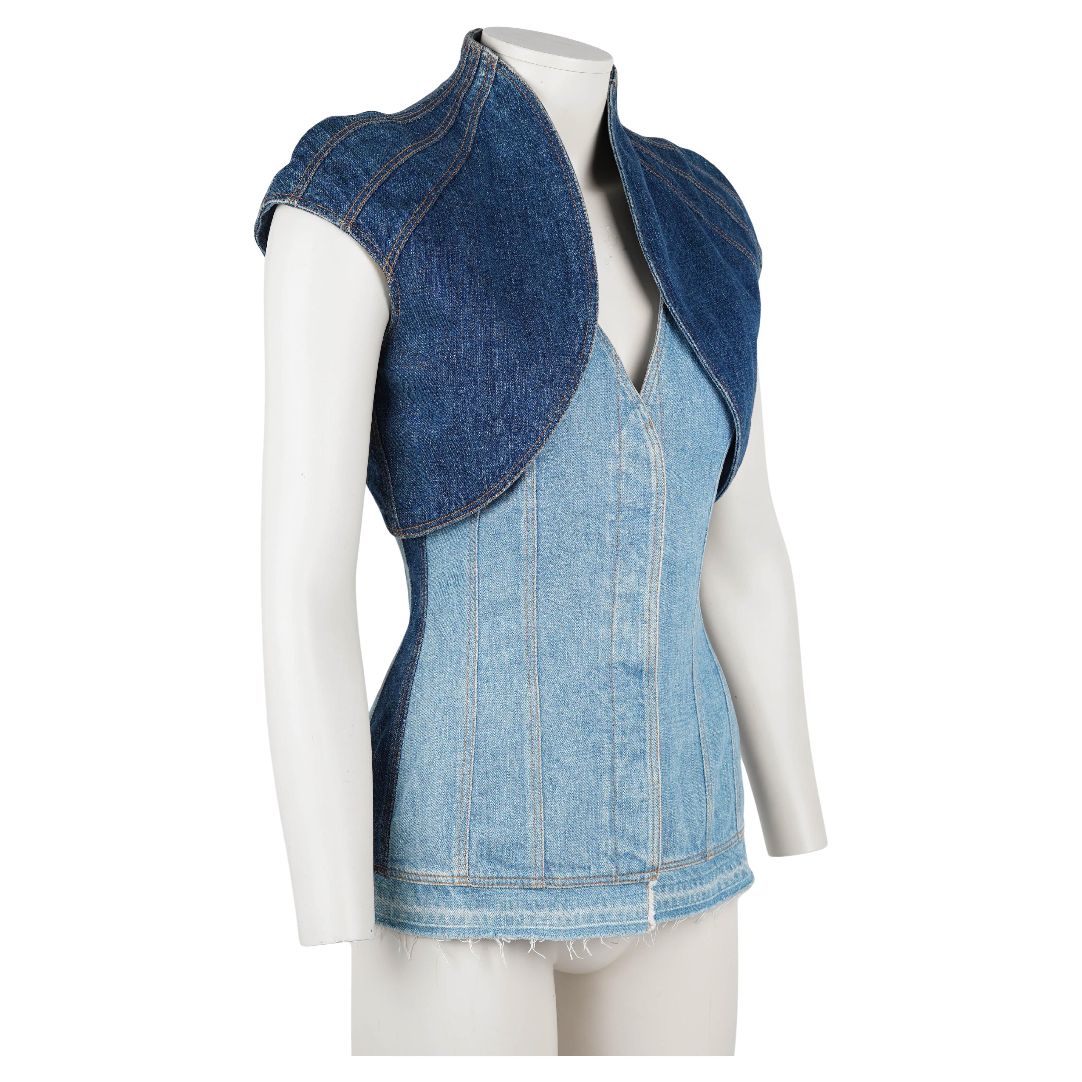 Rare and highly collectible denim corset from Alexander McQueen’s Fall/Winter 2002 runway collection. Constructed in contrasting panels of light and dark washed denim, it is expertly tailored to sculpt and contour the body, featuring signature