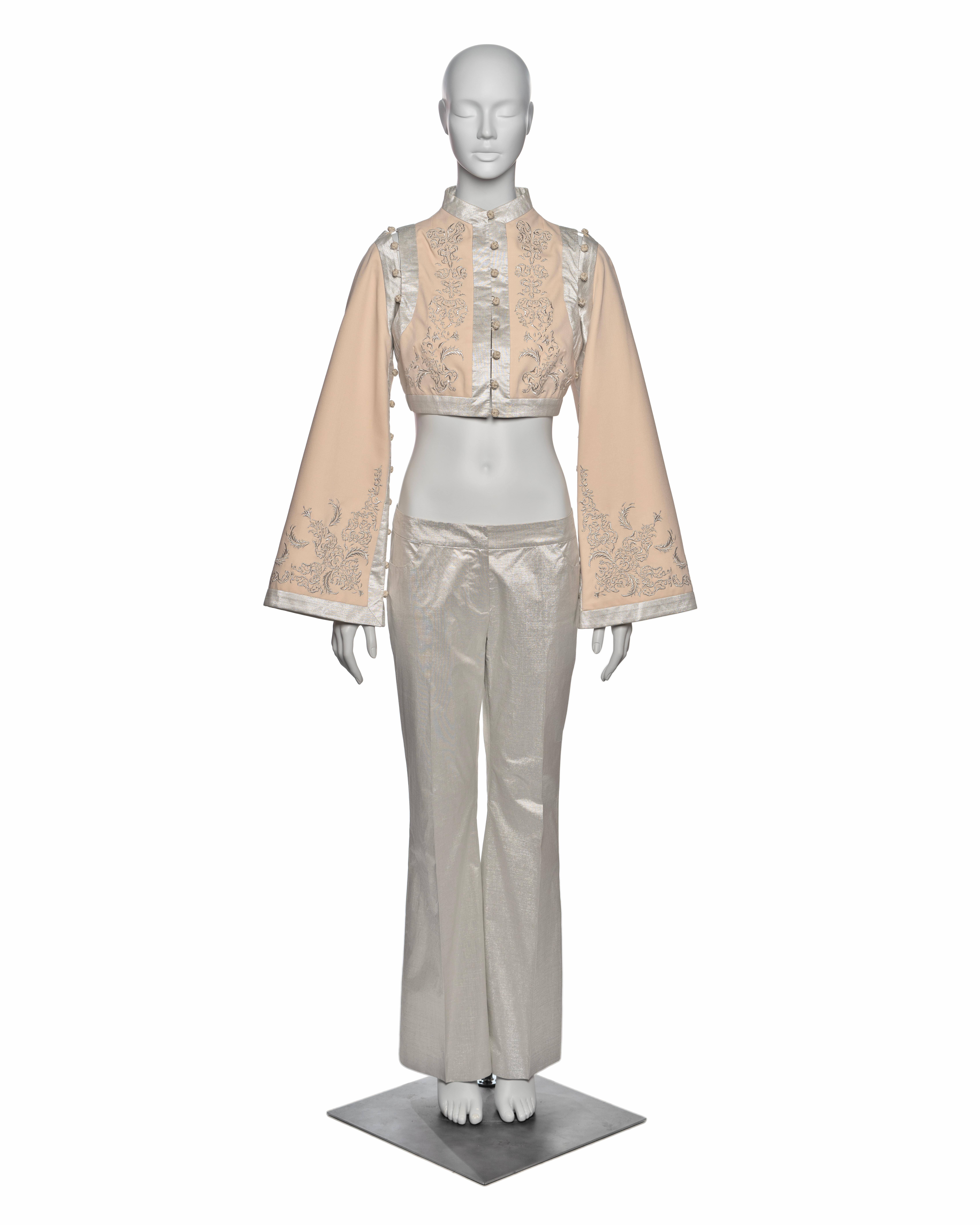 Marchio: Alexander McQueen
Direttore creativo: Lee Alexander McQueen
Collection'S: 'Eye', Primavera-Estate 2000
Fabrice: Cotone, Lurex
Dettagli: La giacca cropped in twill di cotone color crema è caratterizzata da un collo alto alla mandarina,