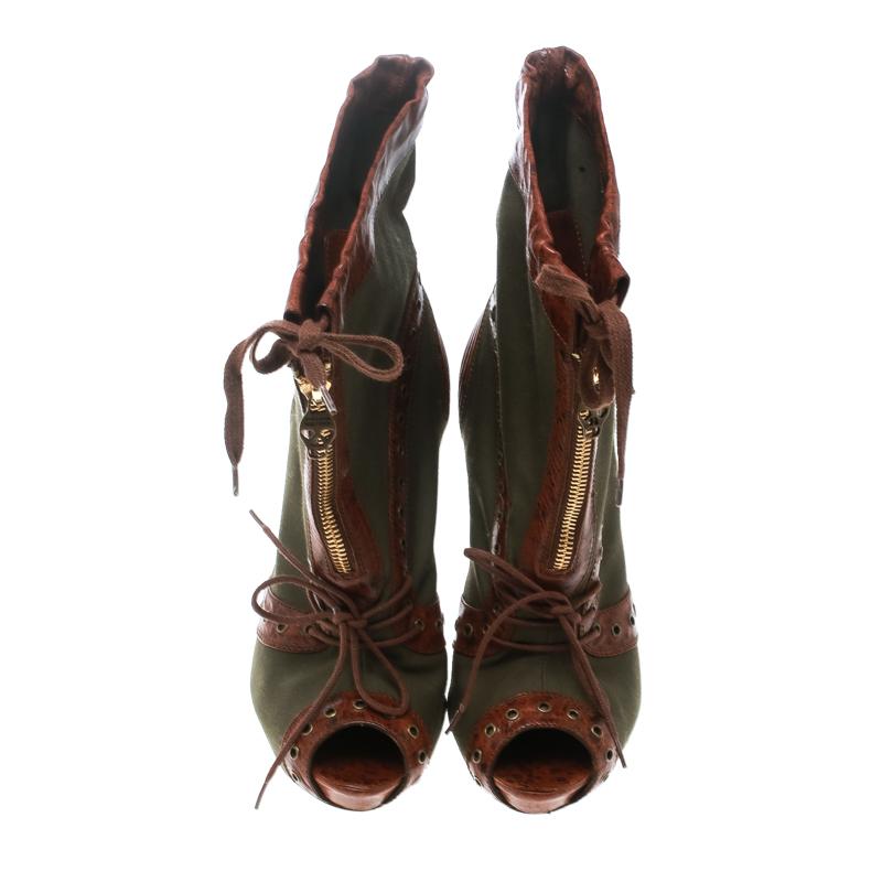 Brimming with artistic excellence are these gorgeous booties from Alexander McQueen! The olive green booties are crafted from canvas and textured leather and feature a peep-toe silhouette. They flaunt a creative detailing of eyelets, lace-ups and,