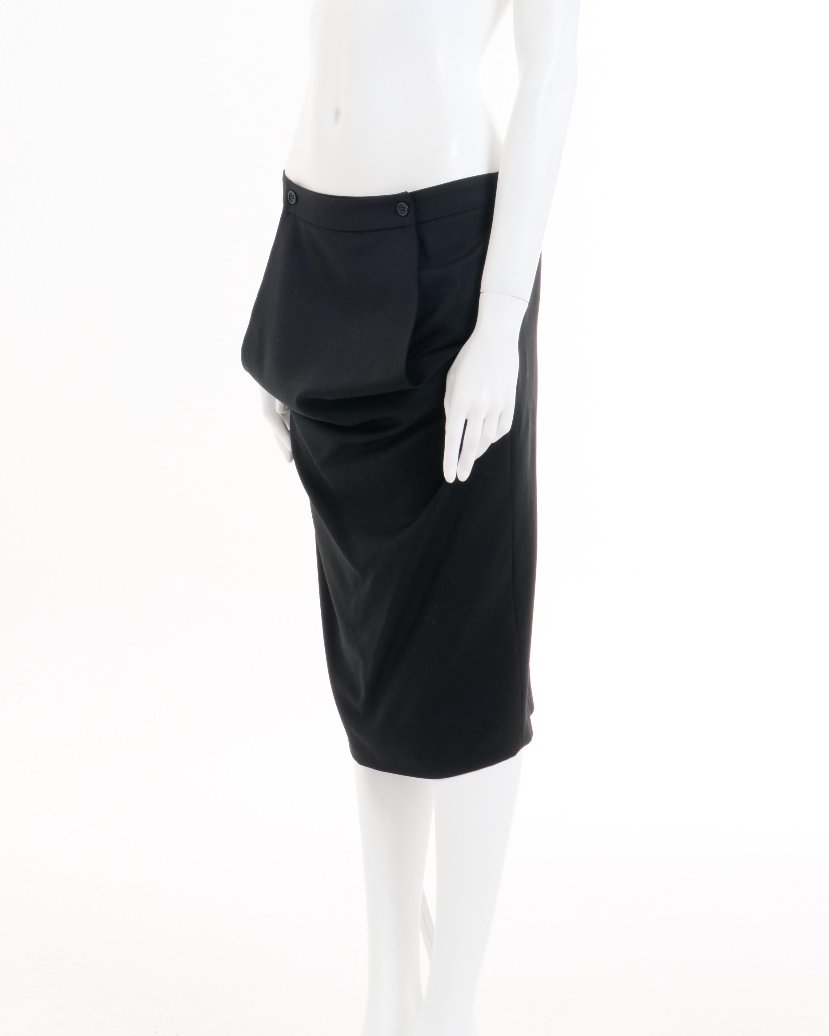 - Sold by SkofArchive
- Alexander McQueen black paneled wool skirt
- Designed by Alexander McQueen 
- Fall-Winter 2001 
- Frontal adjustable panel held by two buttons who create a drape motif 
- Back hidden zipper closure 
- Back split 
- Above knee