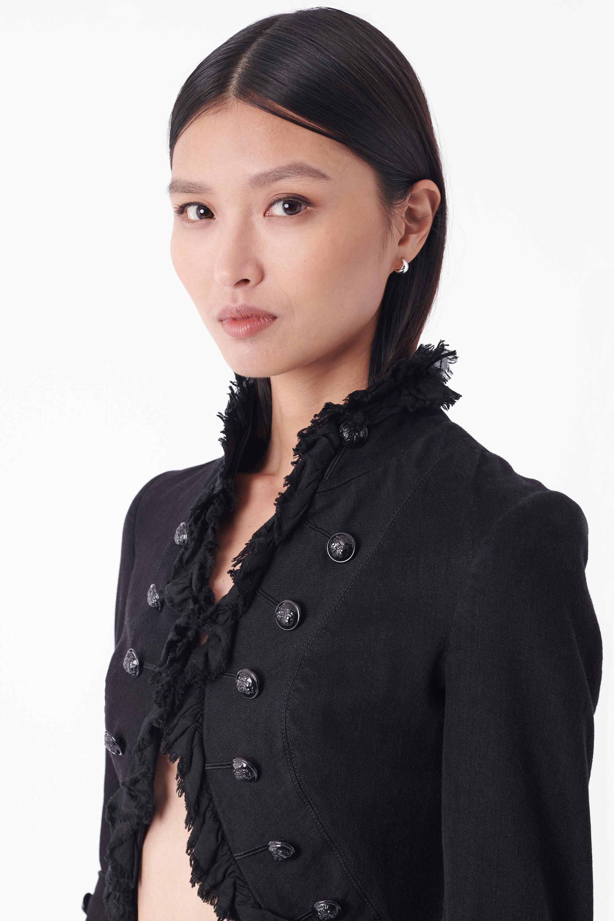 We are excited to present this Alexander McQueen Fall Winter 2008 black British-colonial style jacket. Features distressed ruffle along the neckline, black buttons along the front of the jacket with inner hook & eye closure, pleats style back and