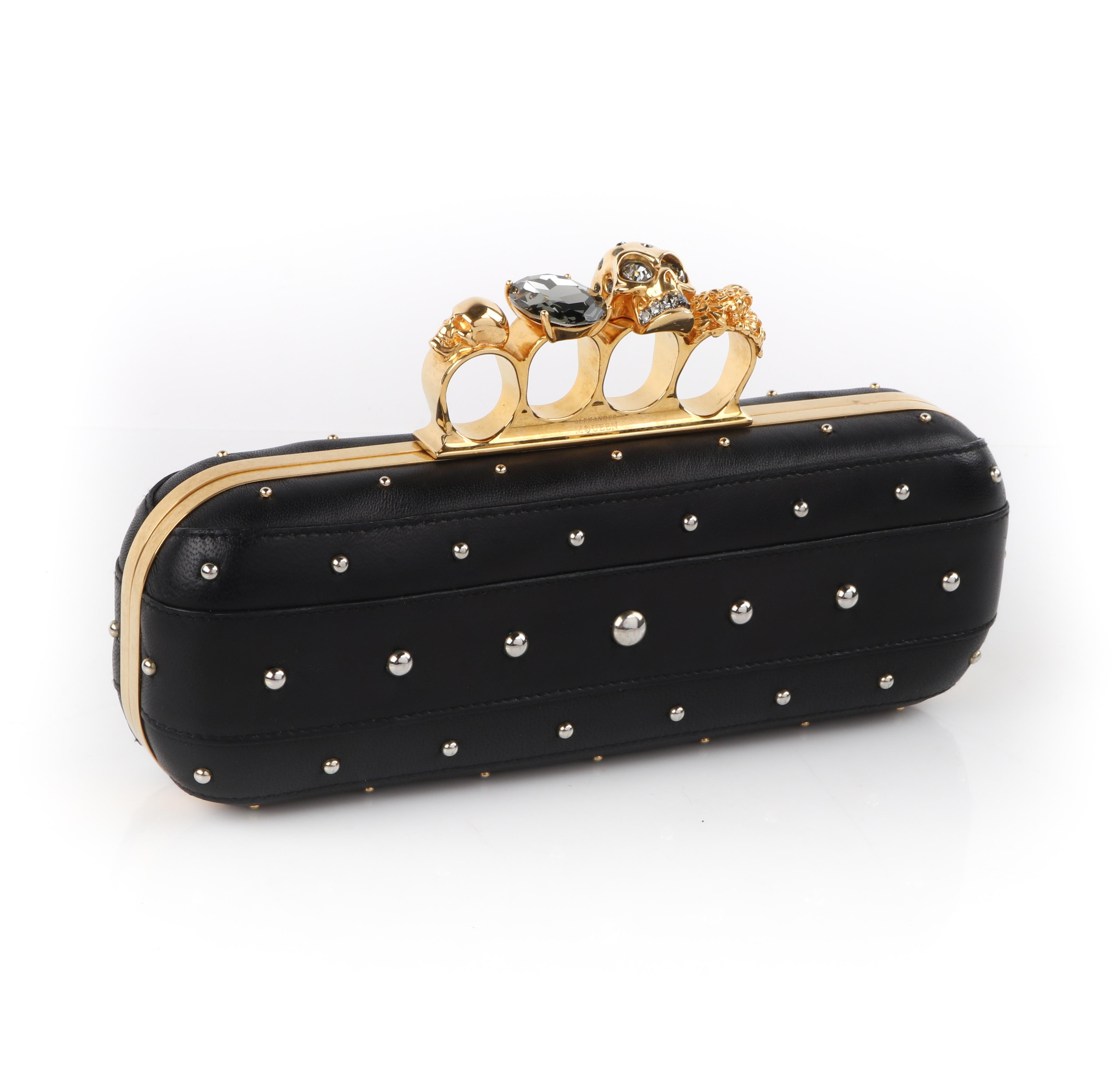 Brand / Manufacturer: Alexander McQueen 
Collection: F/W 2013
Designer: Sarah Burton
Manufacturer Style Name: Skull Four Ring Clutch
Style: Clutch Handbag
Color(s): Shades of black, gold
Lined: Yes
Unmarked Fabric Content (feel of): Leather
