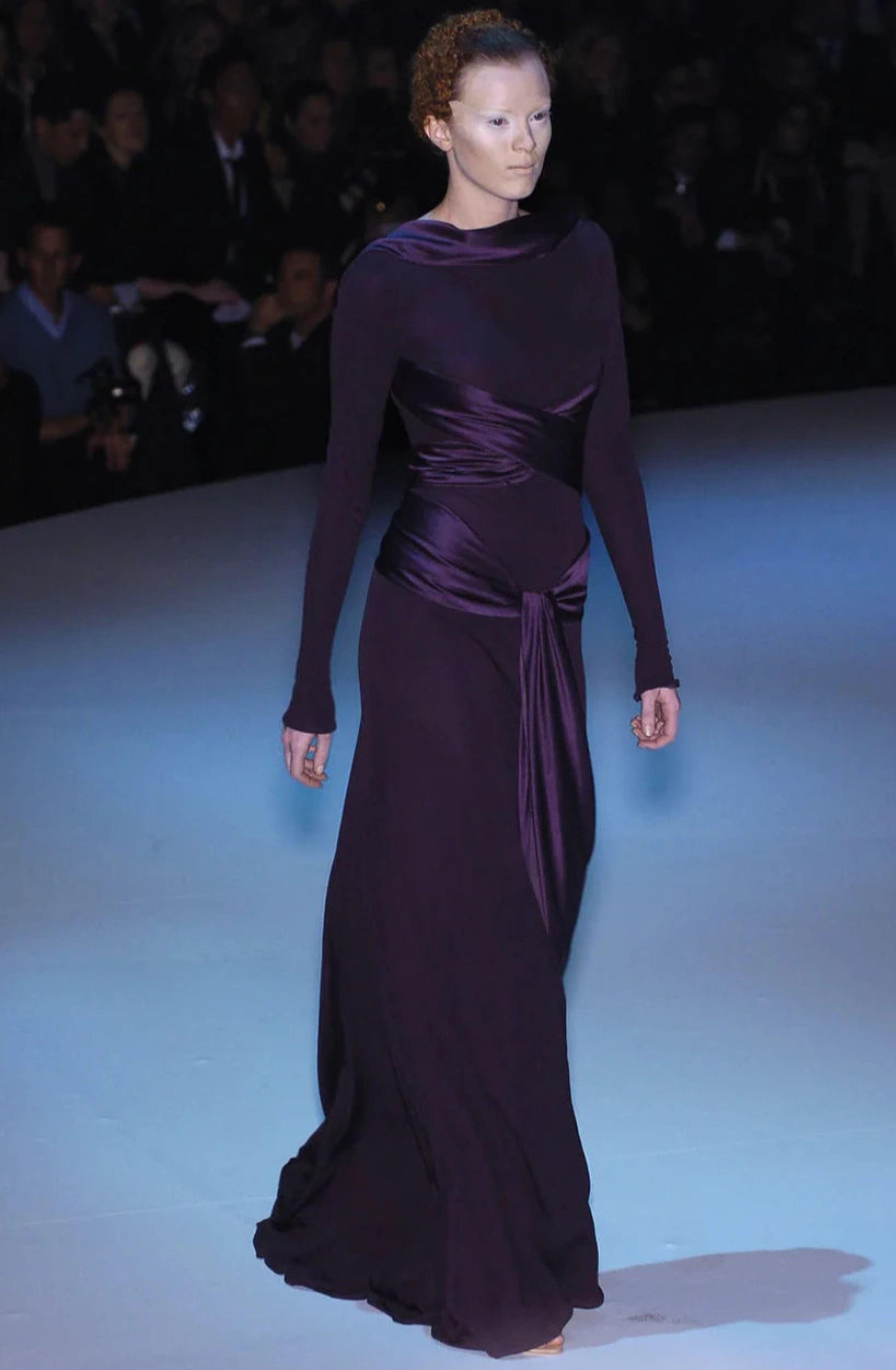 Alexander McQueen
Fall 2004 - seen on the runway and worn multiple times by Queen Mary of Denmark

Deep purple gown with silk satin twist & tie up detail
Long sleeves
Zip up back

53% silk
47% rayon

Stretch fabric

Size IT 40 / UK 8 / US
