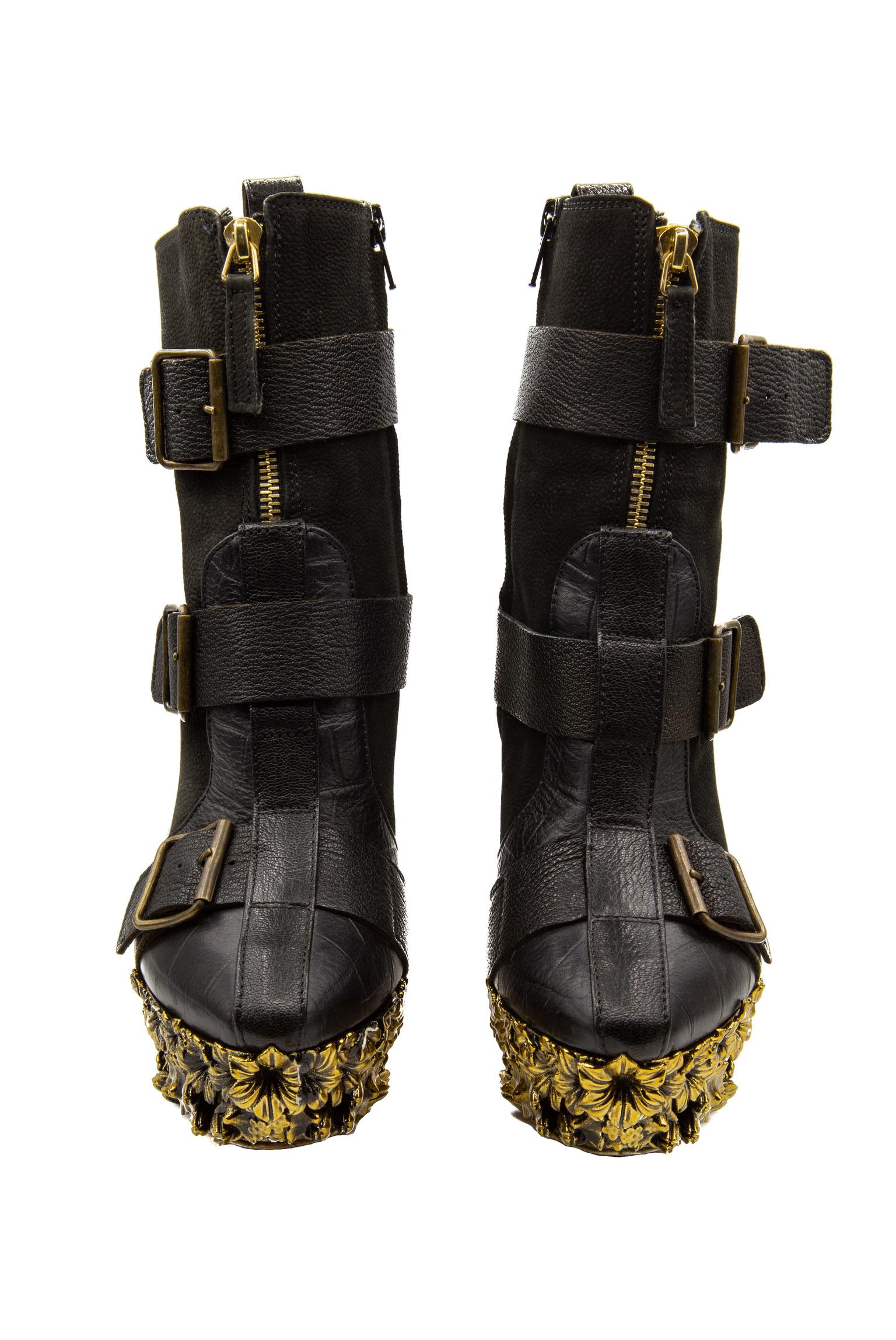 Alexander McQueen Fall 2010 Ready-To-Wear Black Leather Ankle Boots with a gold floral metal platform and three leather straps with gold buckles. These ankle boots were featured on the Angels and demons runway in look two - as modelled by Alla