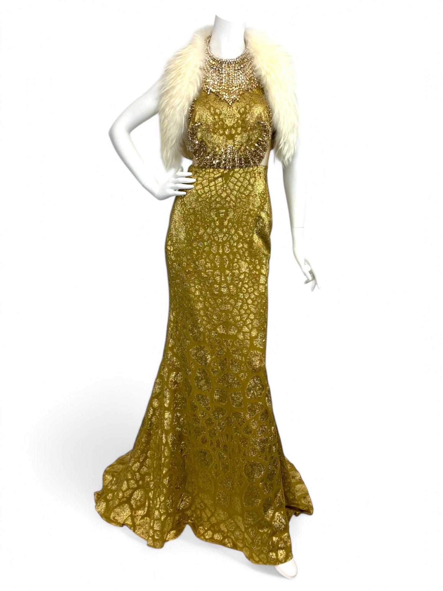 A masterclass in opulence and silhouette, this Alexander McQueen gold evening gown is a breathtaking example of the house’s dramatic elegance and couture-level craftsmanship. Meticulously embellished with intricate jeweled detailing throughout the