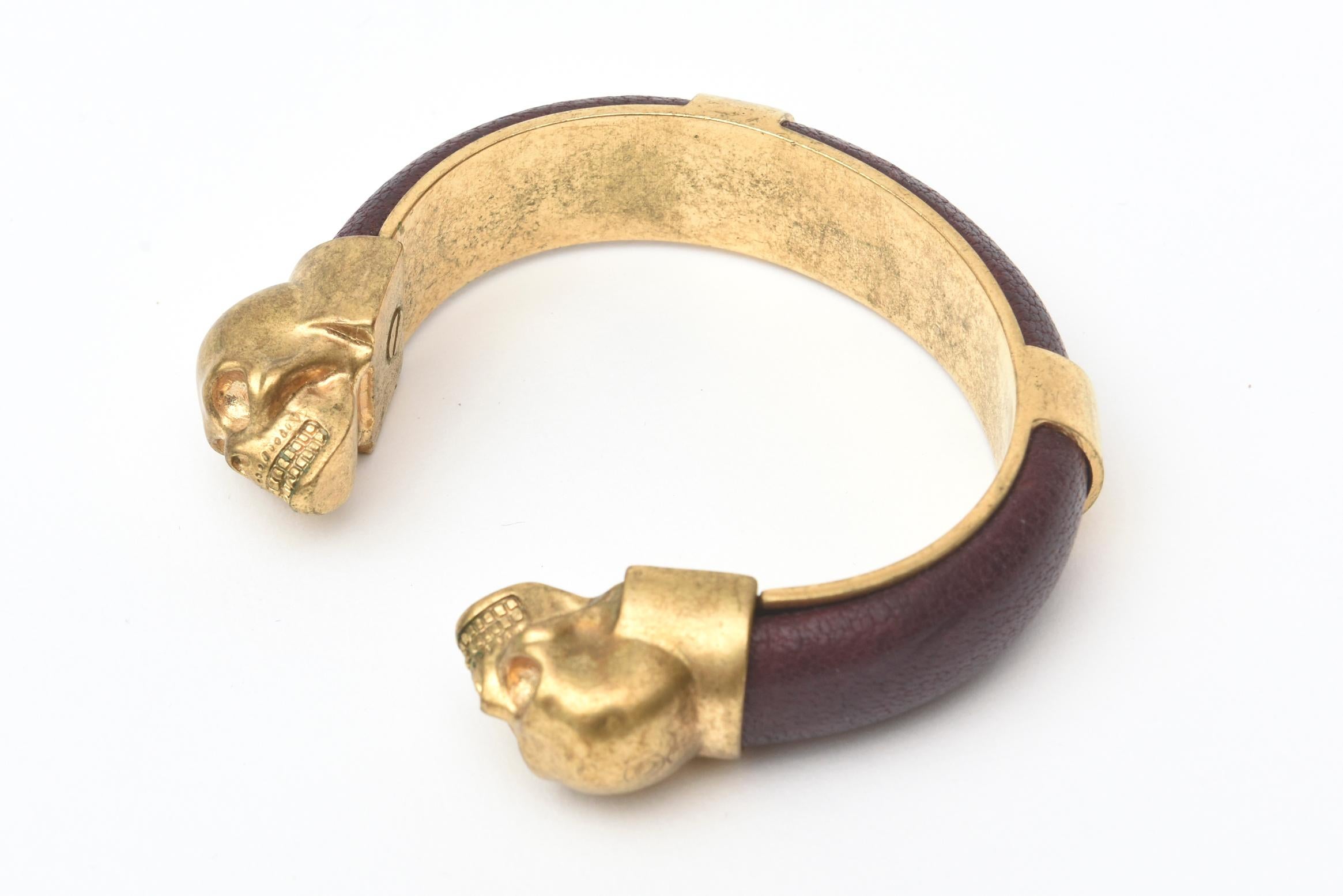 This fabulous and iconic Alexander McQueen gold plated and aubergine brown pebbled leather bracelet can be worn two ways. it acts as a bangle or a small cuff bracelet and of course can be paired with other bracelets in gold to create a sculptural