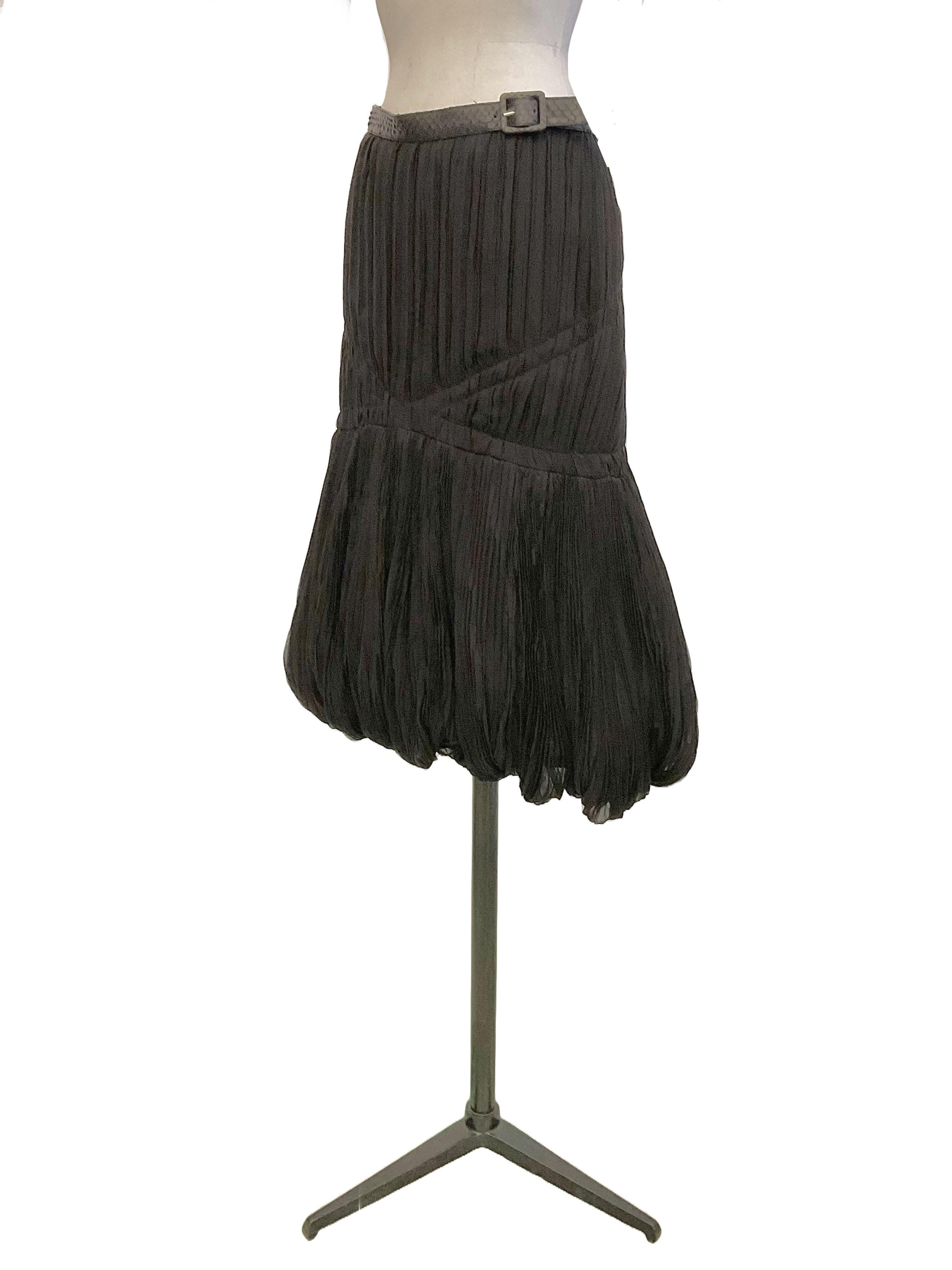 Black silk balloon skirt with python belt by Alexander McQueen from the Ready to Wear Fall Winter 2008 collection.
The surface of the skirt is moved by vertical pleating
irregular.
Ribbons sewn on the front that continue on the back simulate